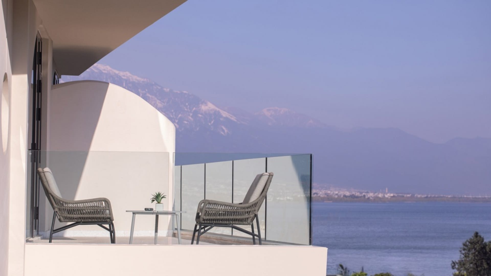 Modern vacation home with a glass balcony overlooking the sea.