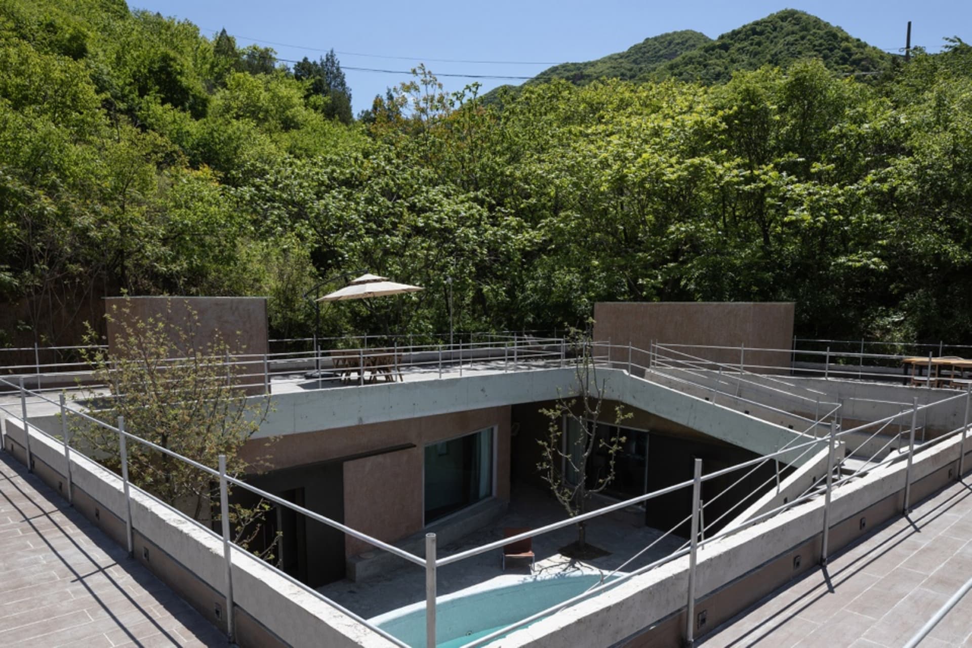 Modern house exterior with a concrete facade and outdoor seating area.