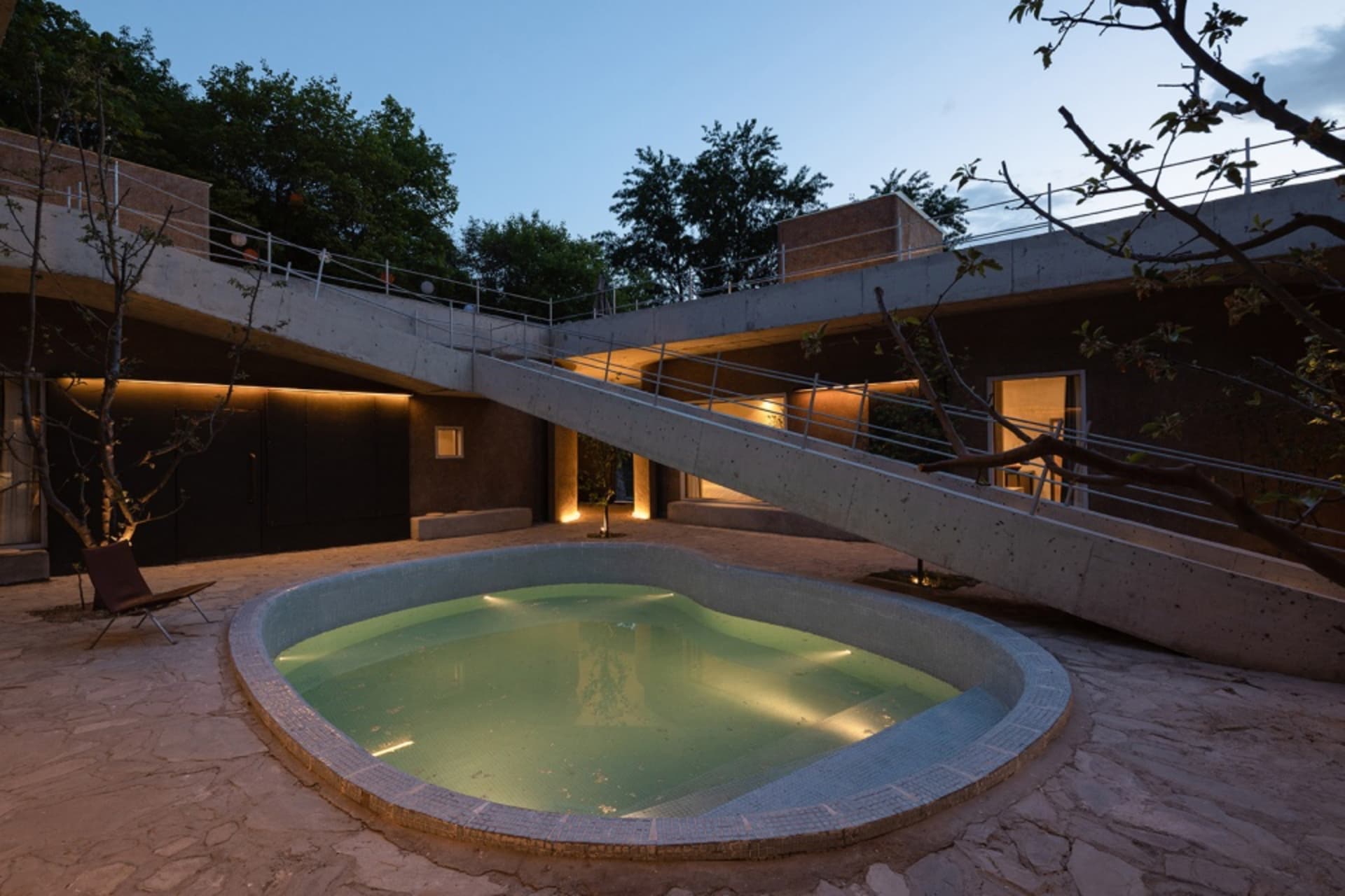 Modern house exterior with concrete bridge at night