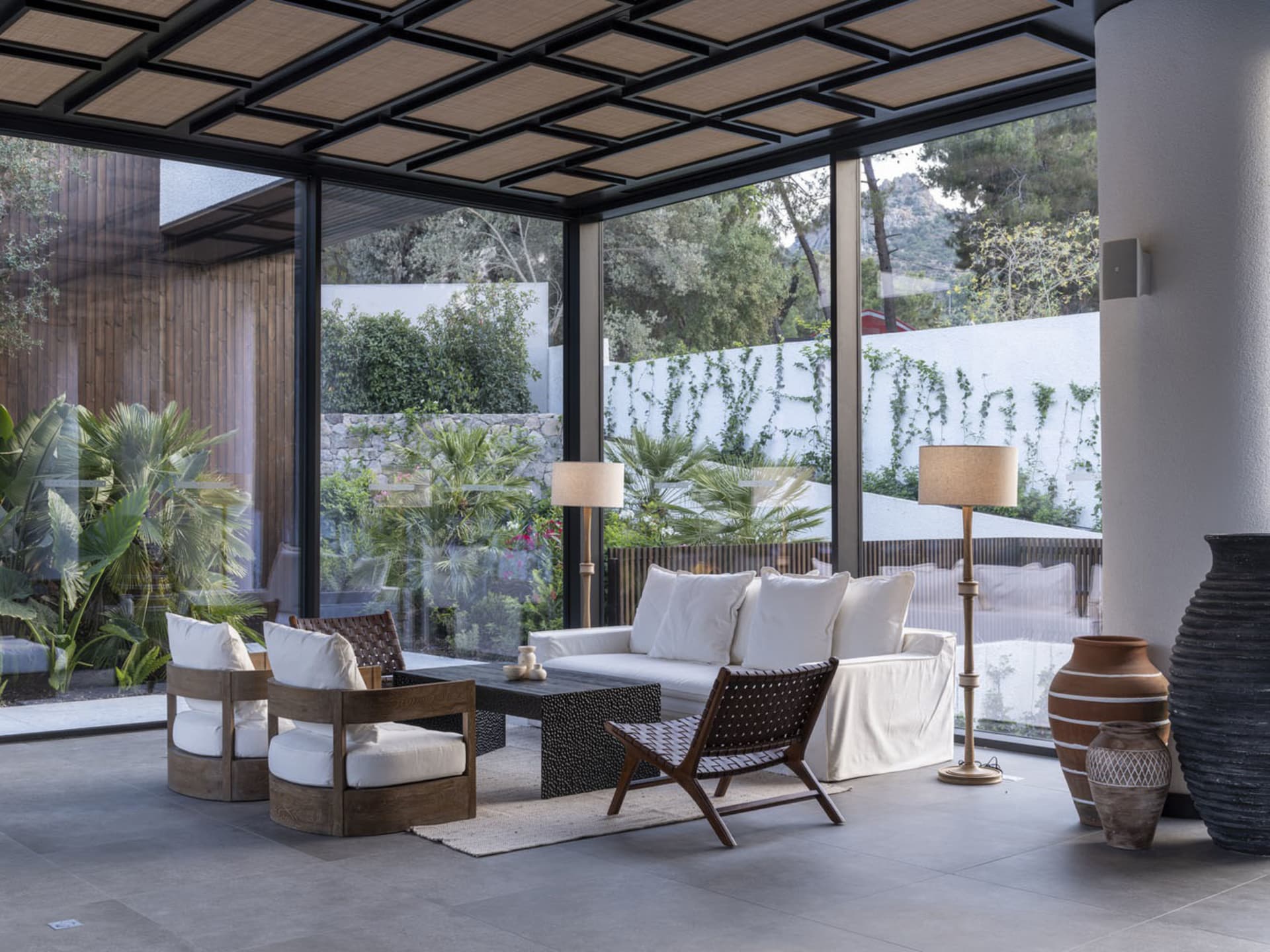 A modern living room with glass walls and wooden furniture.