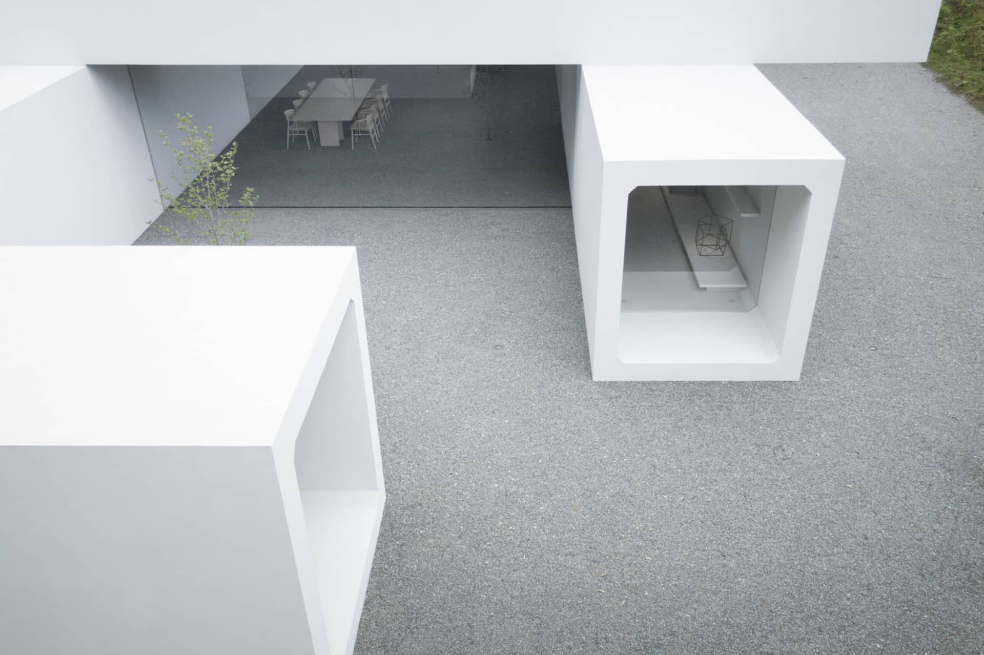 A minimalist architectural design with a white concrete structure and a simple, open space.