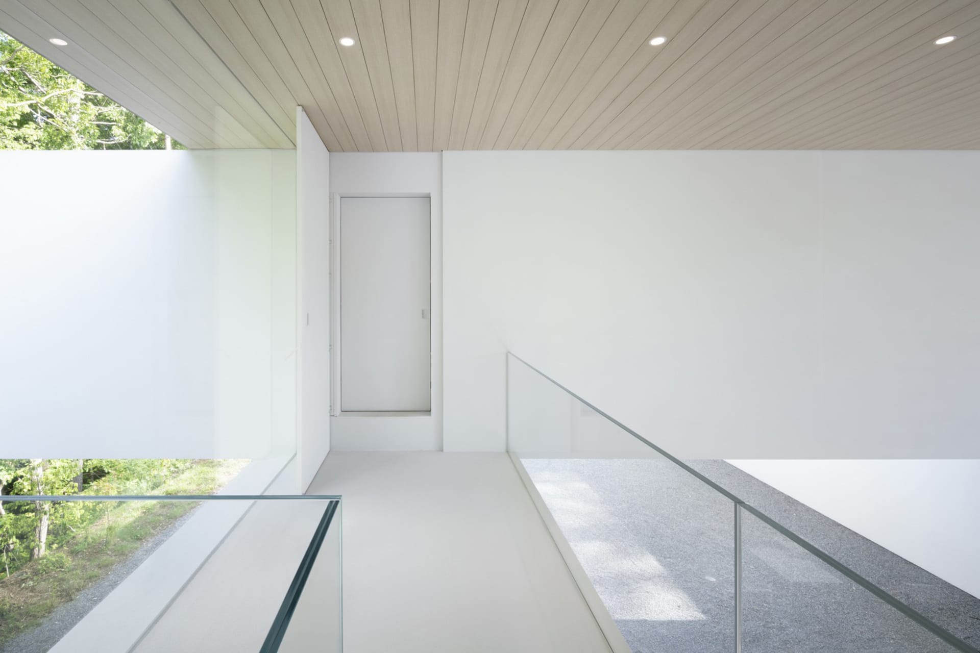 Modern minimalist loft interior with concrete, glass, and wooden elements.