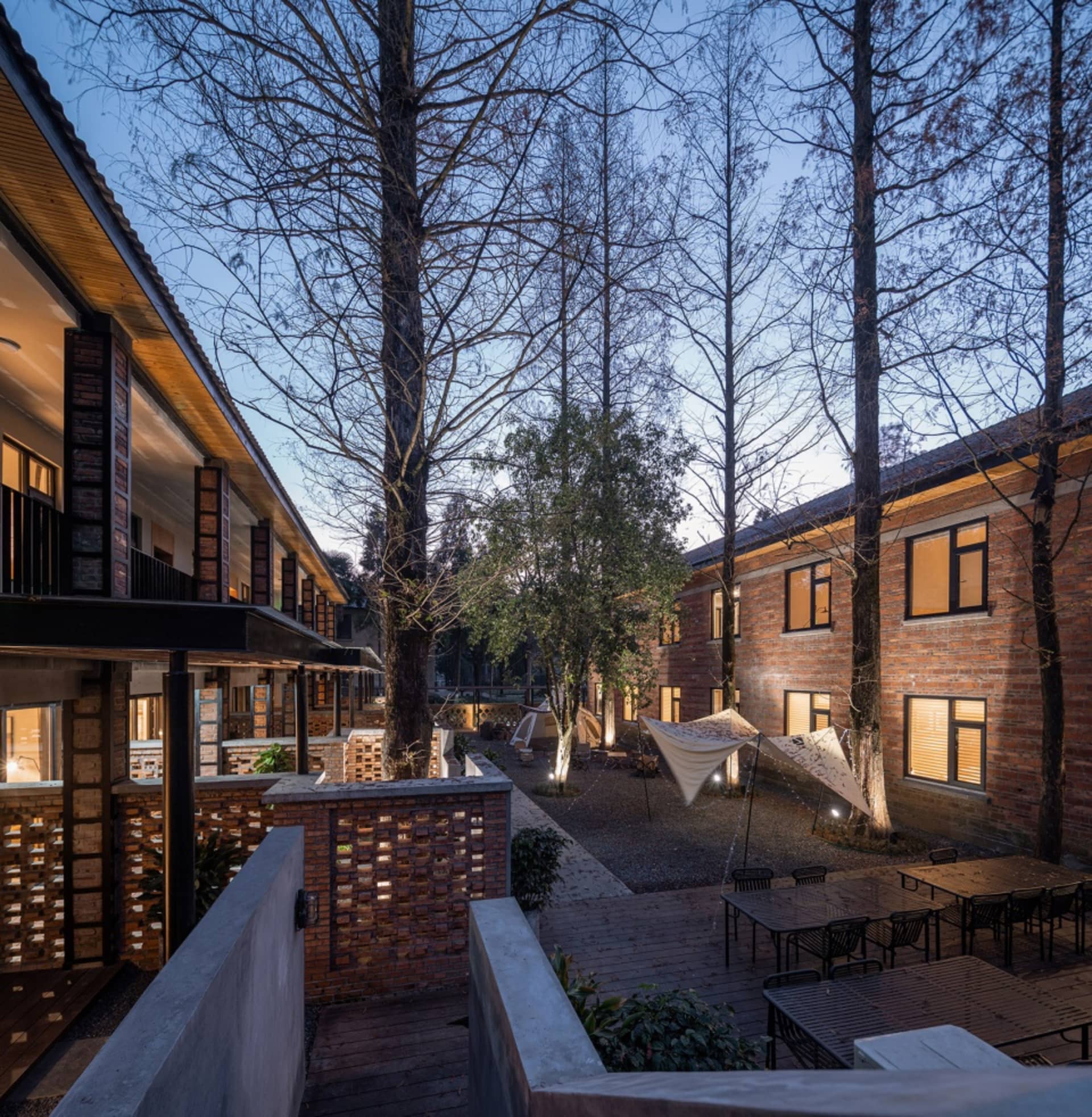 現代磚牆與混凝土住宅建築,搭配戶外座椅與樹木