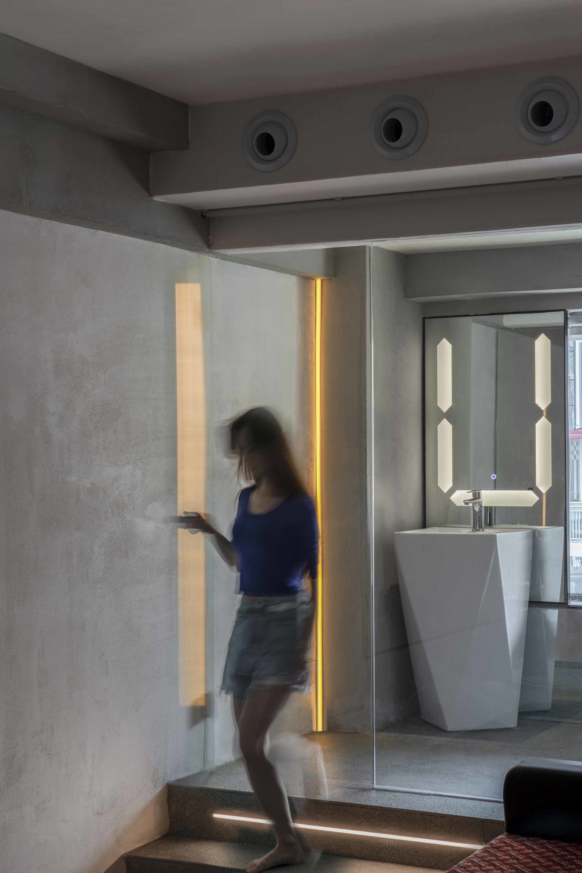 A modern bathroom featuring concrete, glass, and stainless steel materials with an open space design.