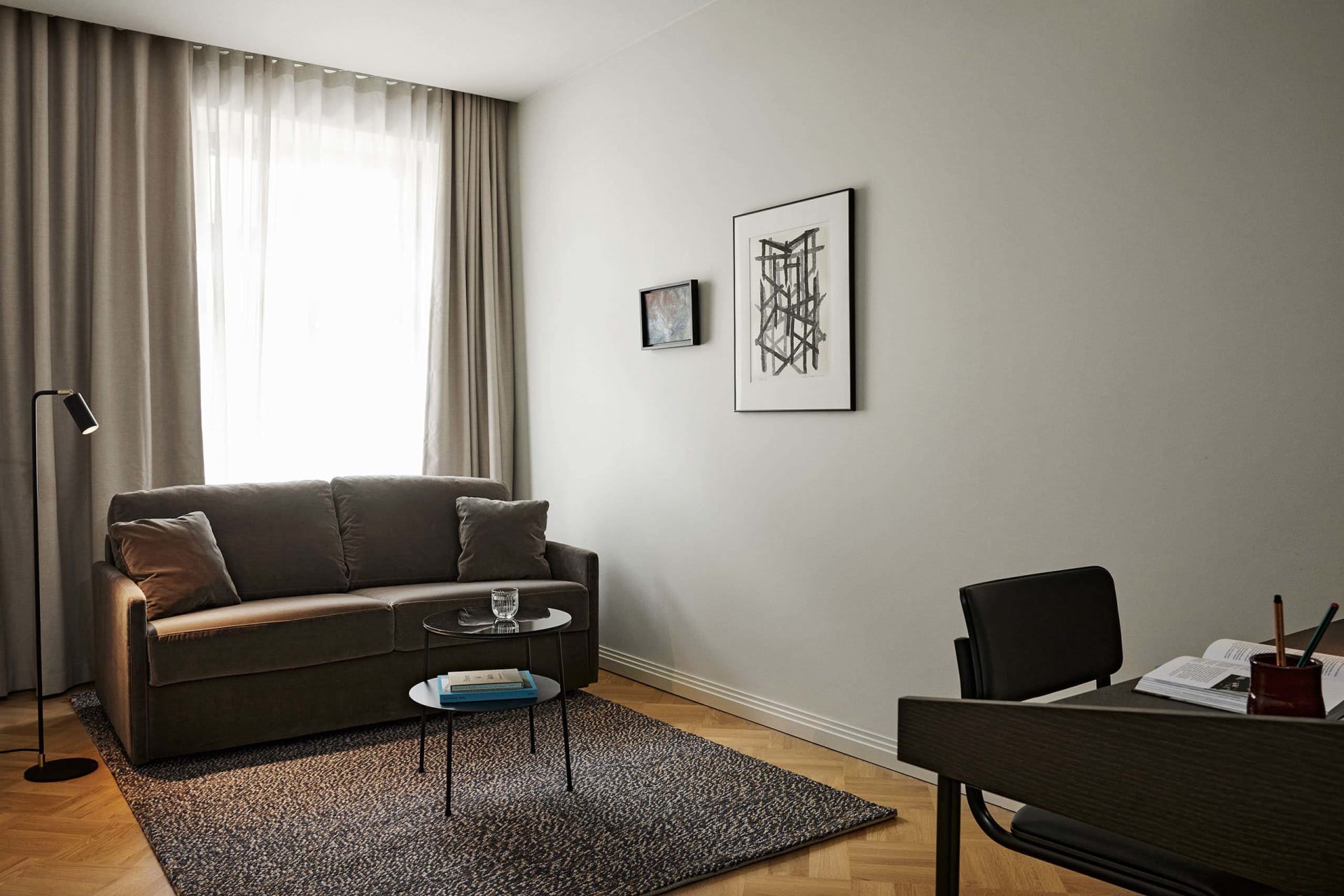 A modern living room featuring a fabric sofa, coffee table, and framed art on the wall.