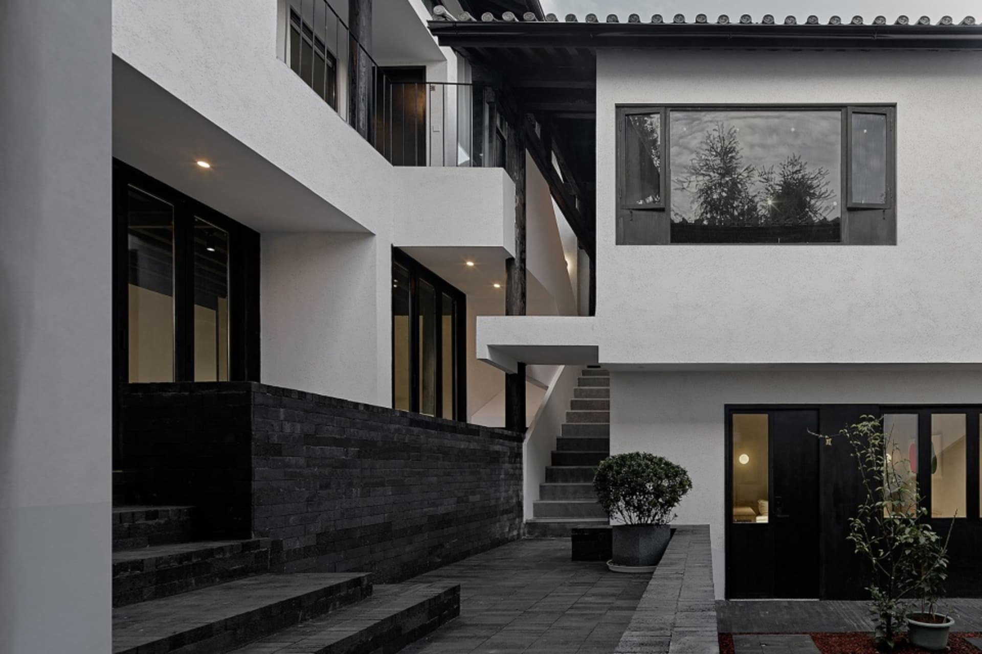 現代住宅立面，採用黑木與混凝土材質。
