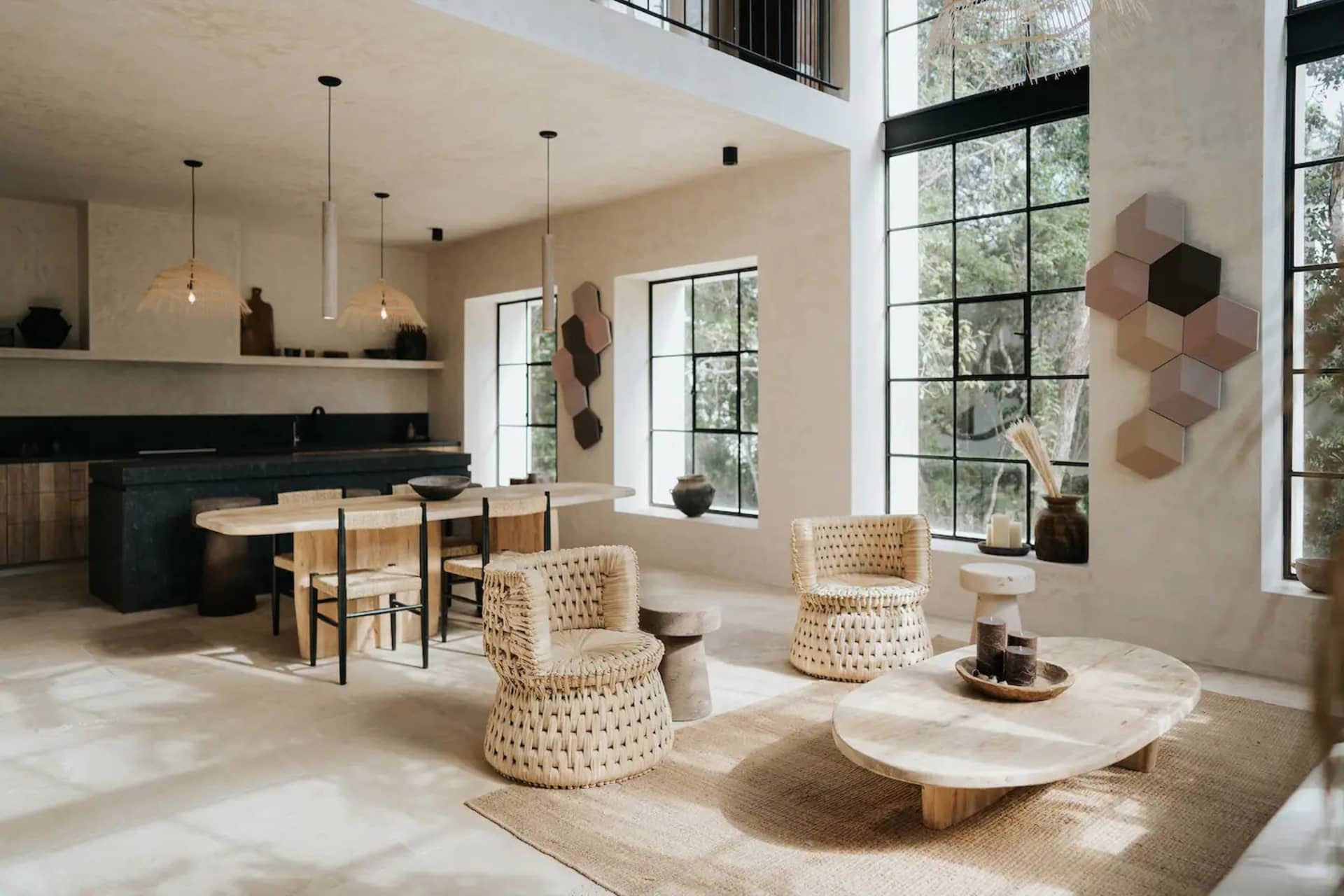 Modern residential living room featuring natural fiber furniture and jute rug, with large windows and light-colored walls and