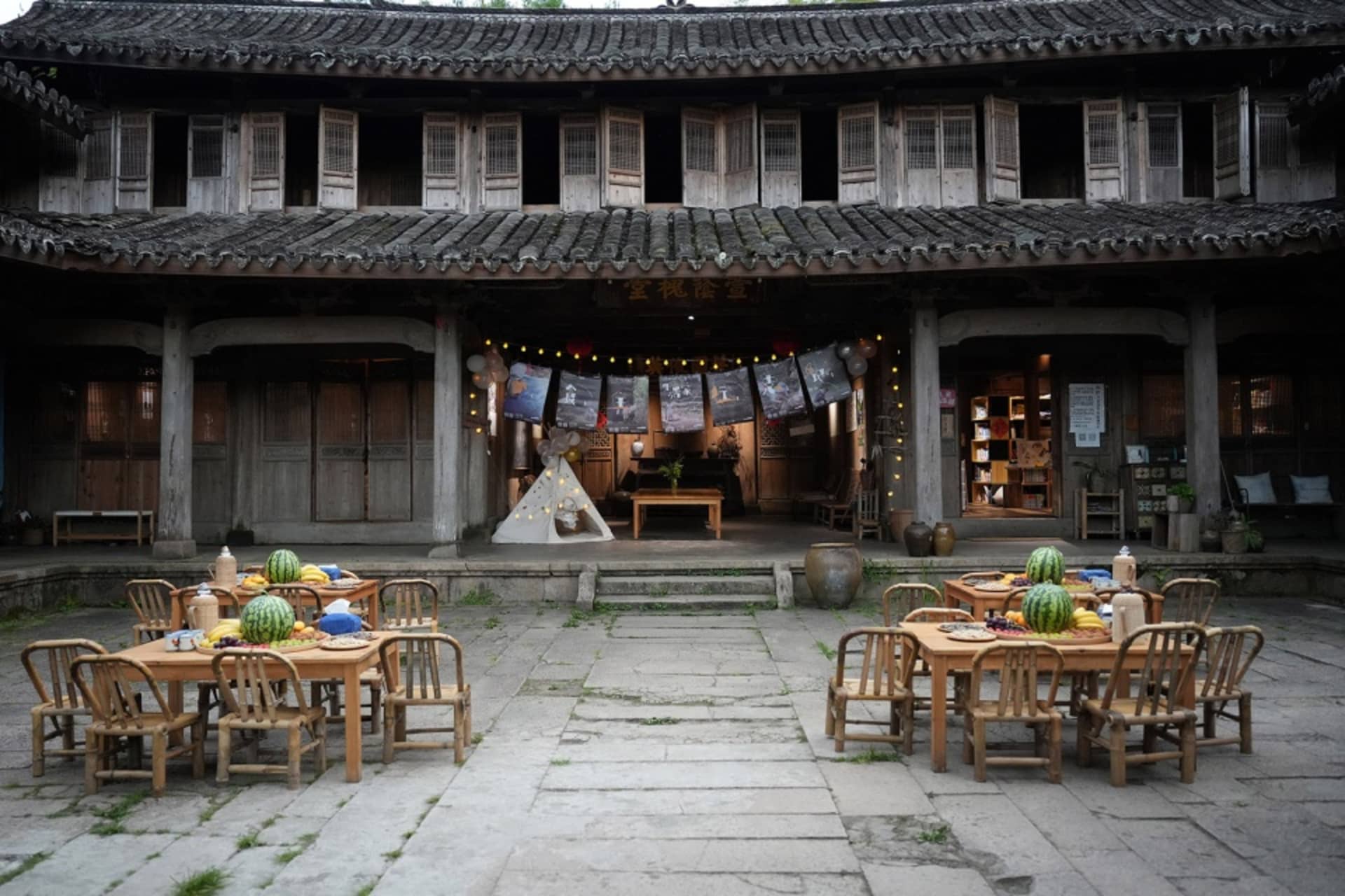 傳統中式建築前設有木製桌椅的戶外座位區,屋頂覆蓋傳統瓦片與木質結構
