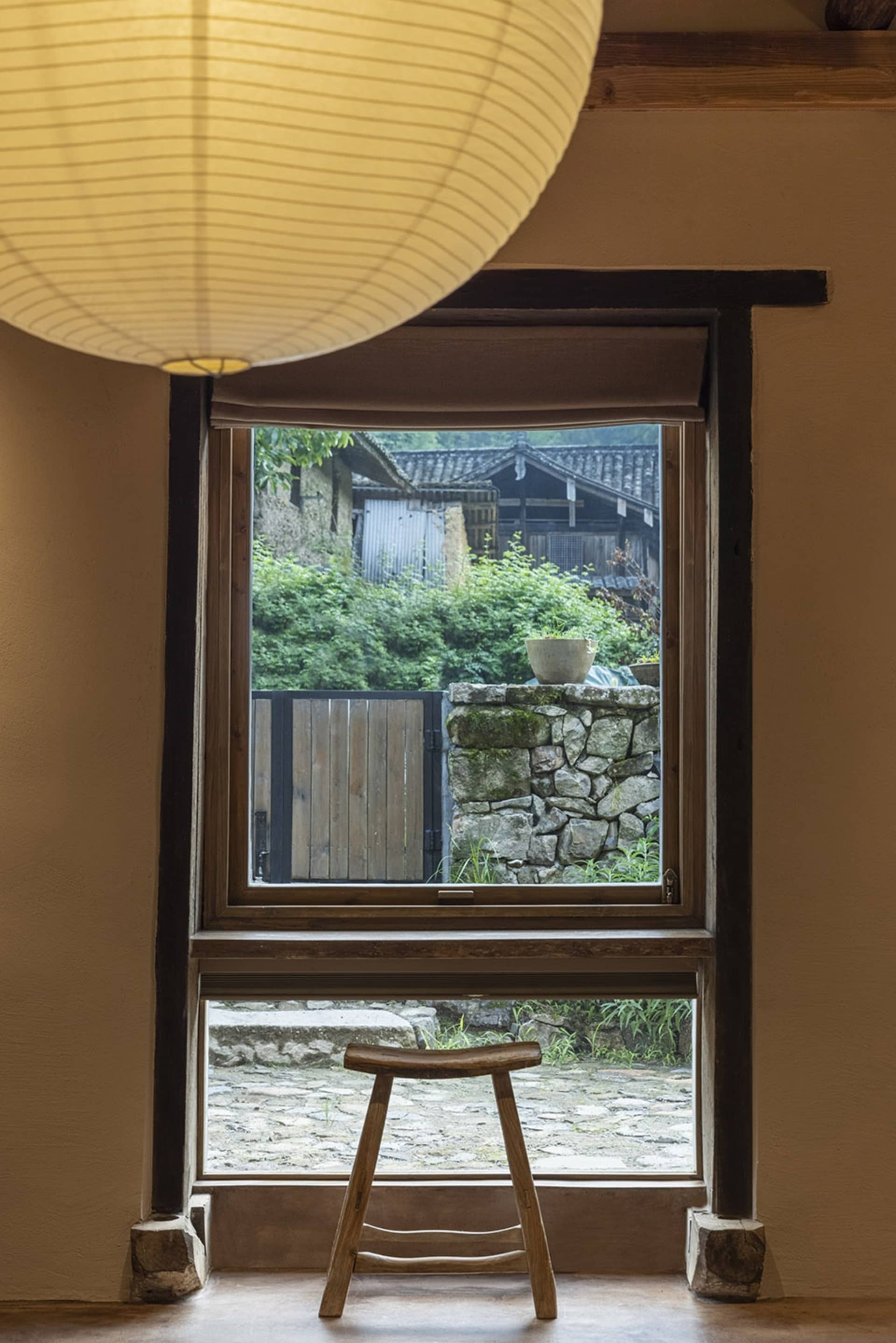傳統室內景觀，窗外可見石牆圍繞的鄉村花園，搭配木質元素。