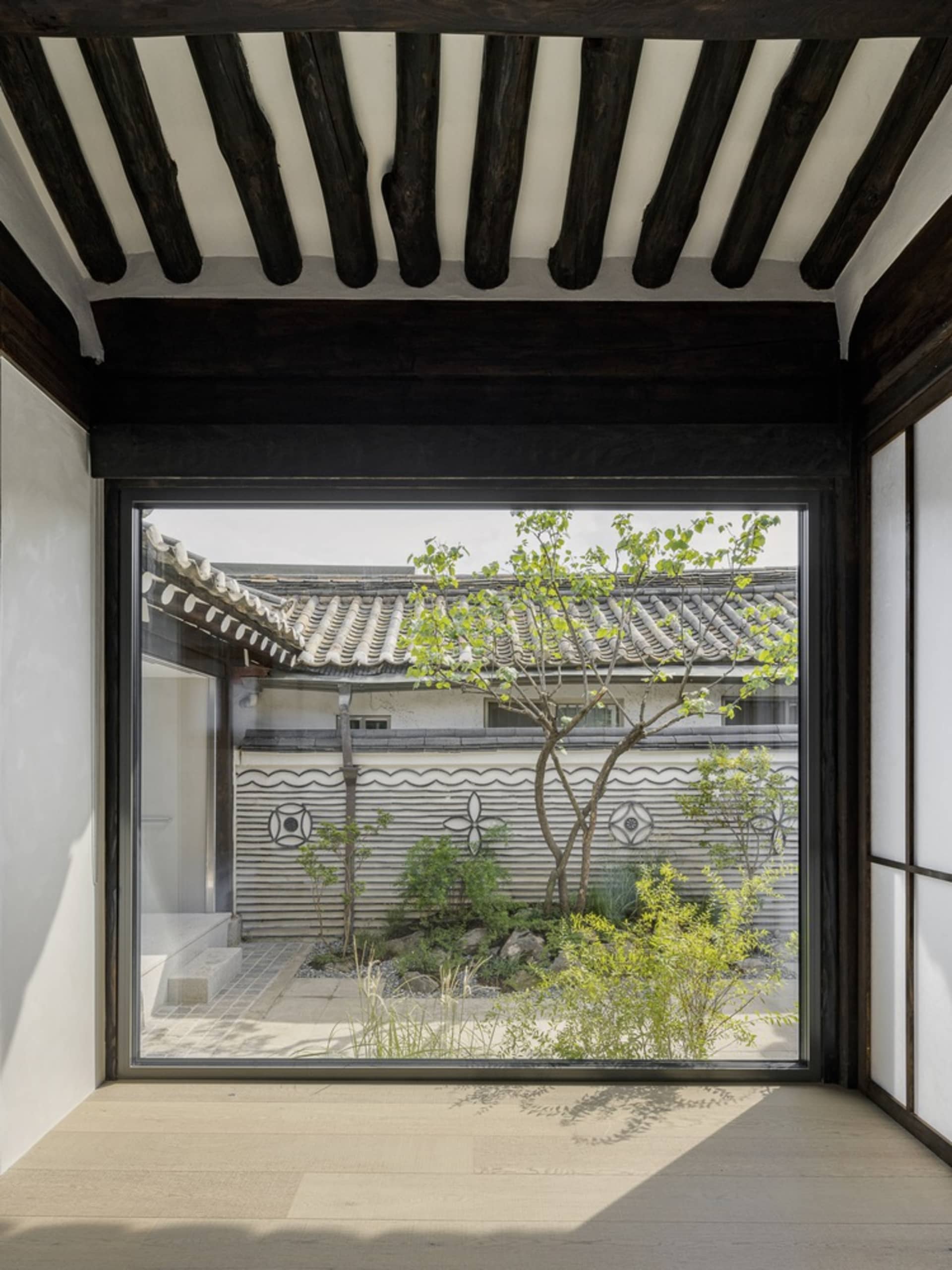 現代住宅室內,玻璃牆面搭配木質地板與橫樑