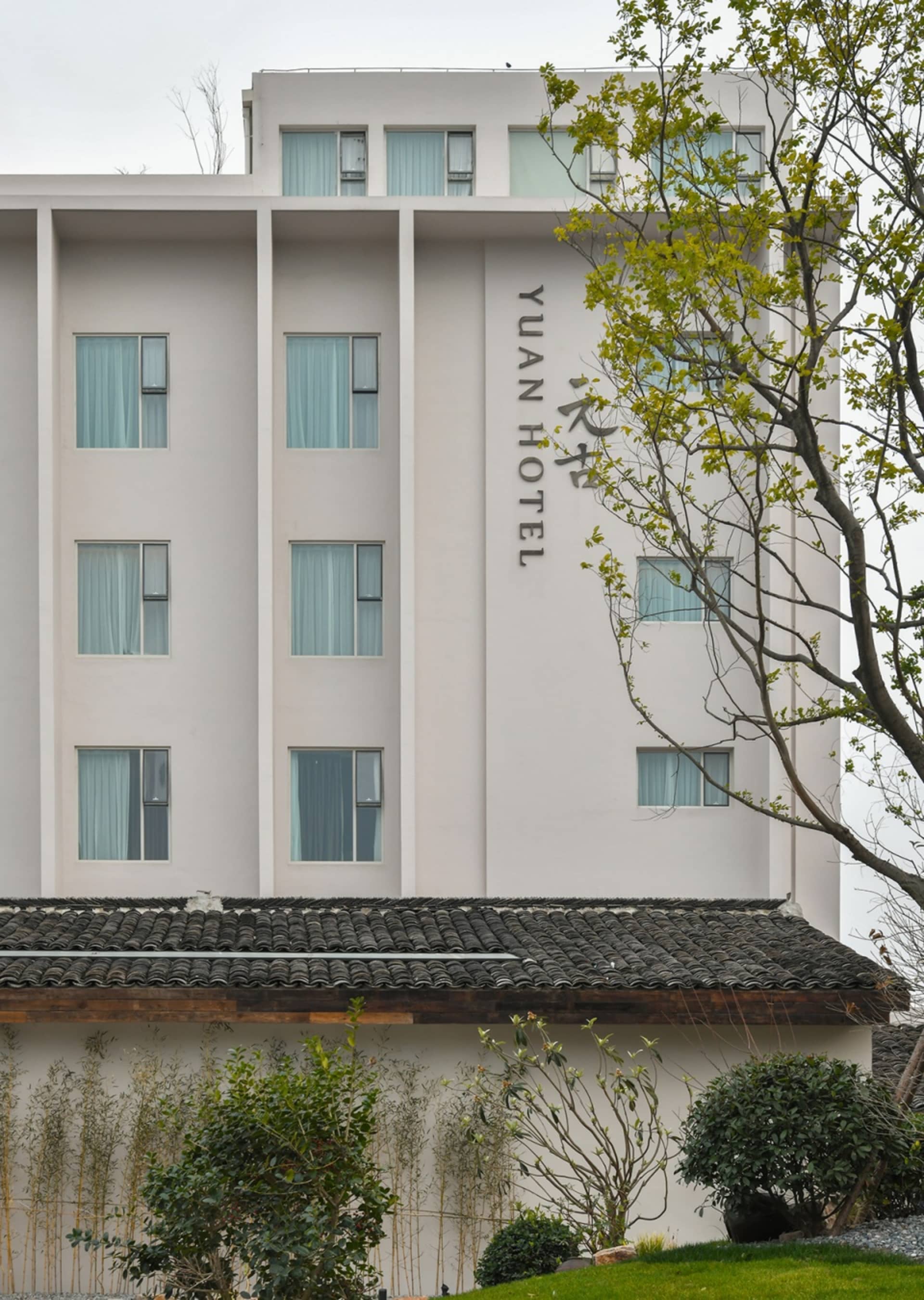 現代酒店建築,擁有白色外牆與灰色混凝土屋頂。