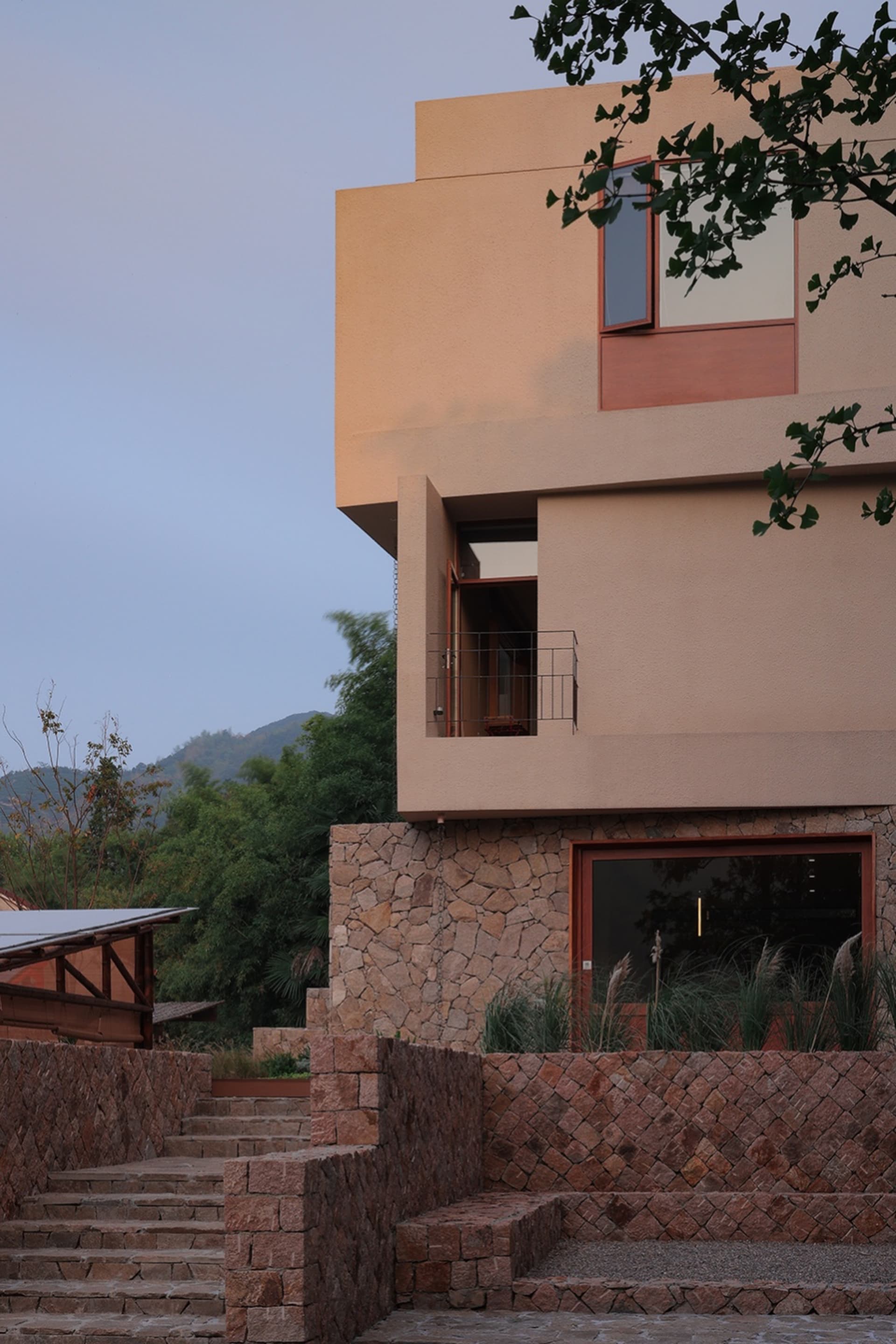 Modern residential architecture featuring concrete and glass on a hillside.
