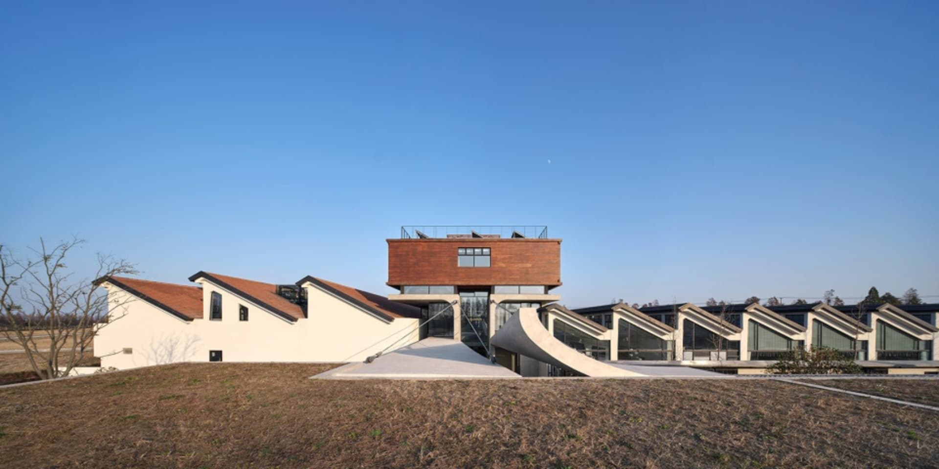 A modern residential mansion with a concrete exterior and large windows.