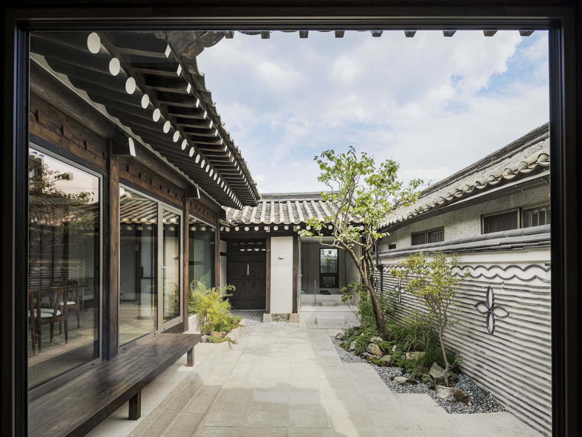 傳統韓式庭院,搭配木造結構、玻璃牆面與石板步道。