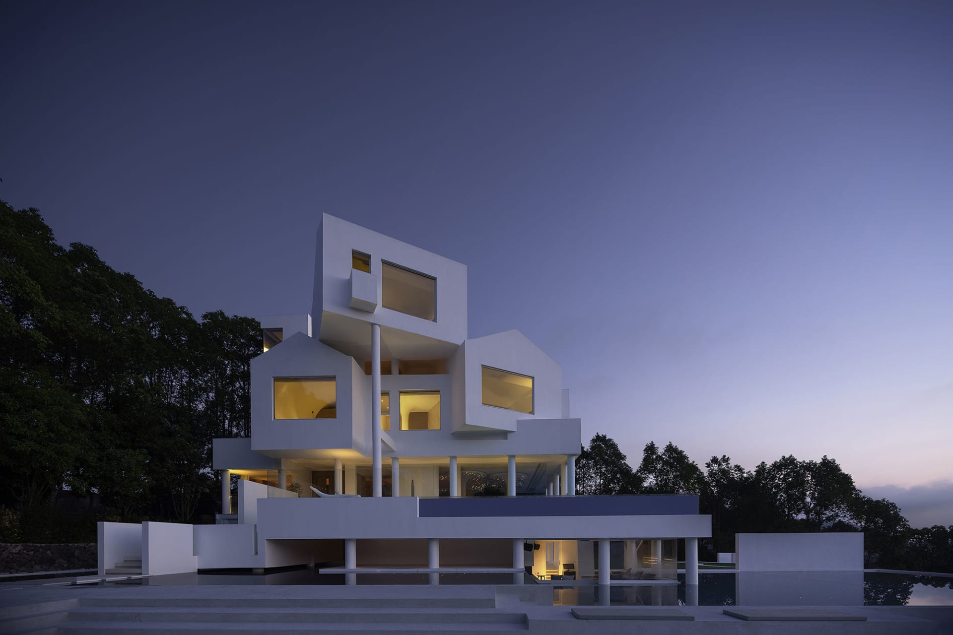 Modern house with white concrete exterior during twilight.