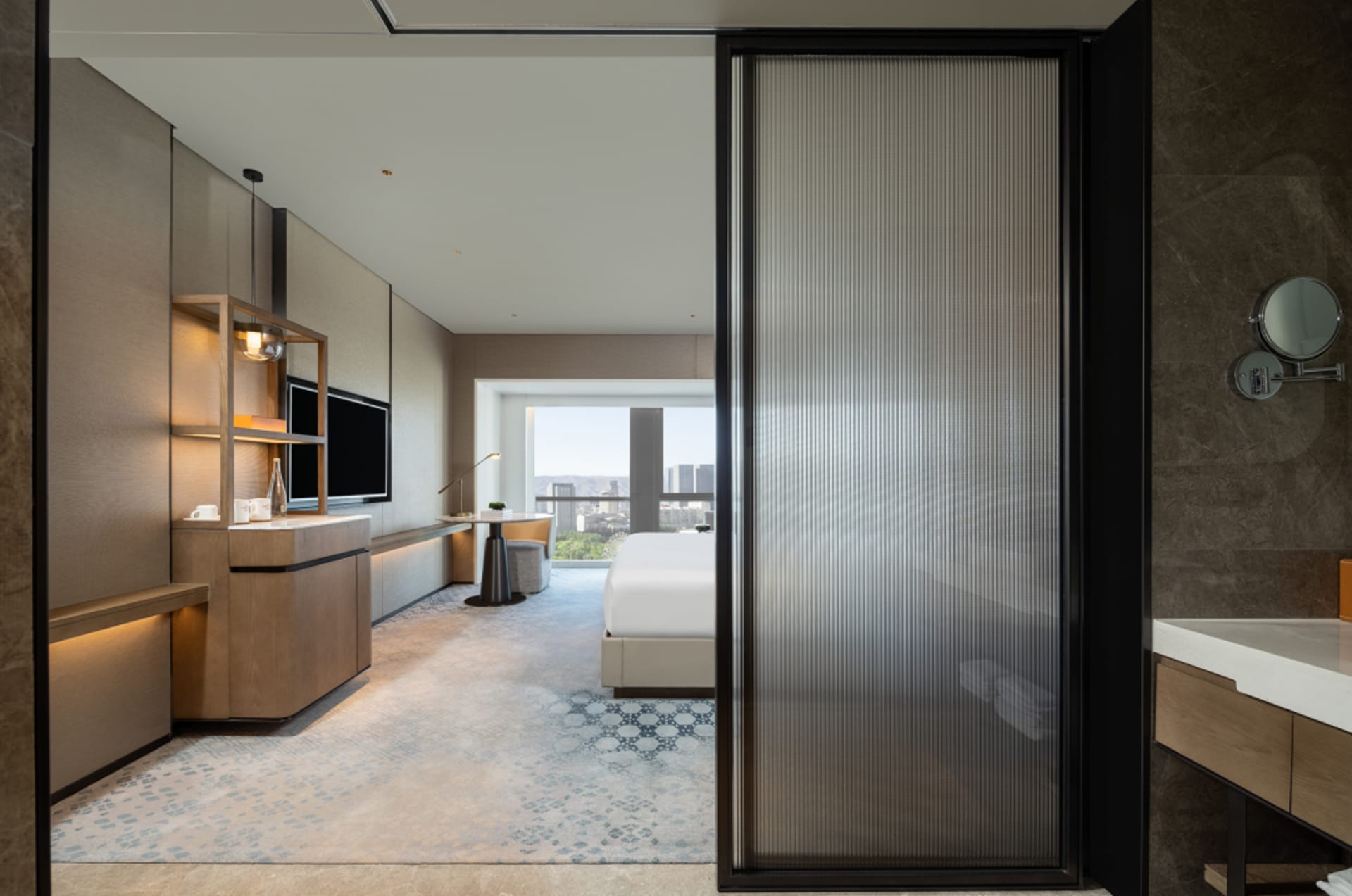 A modern hotel suite featuring marble and glass materials.