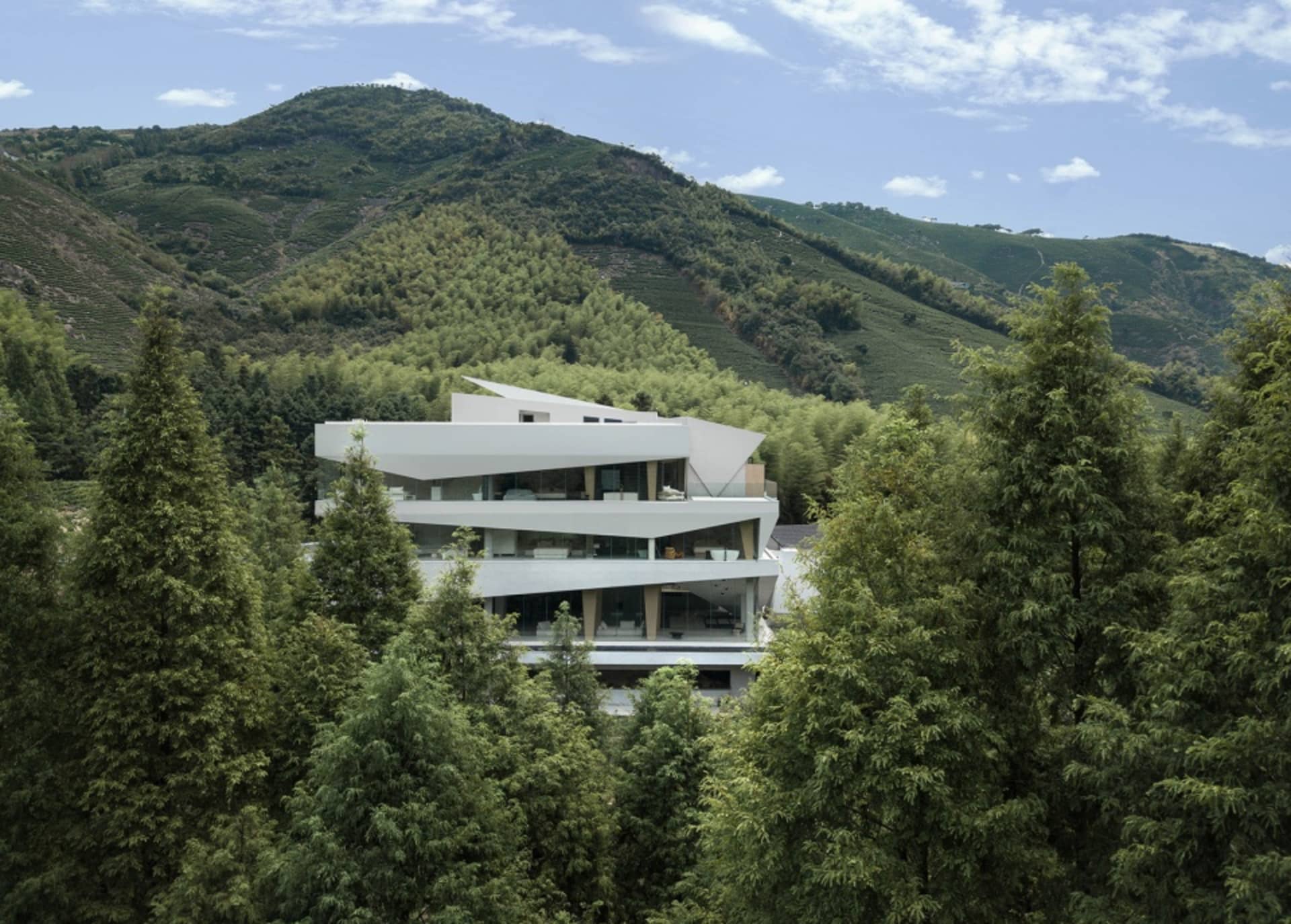 一座現代住宅建築，外牆採用玻璃與混凝土材質。