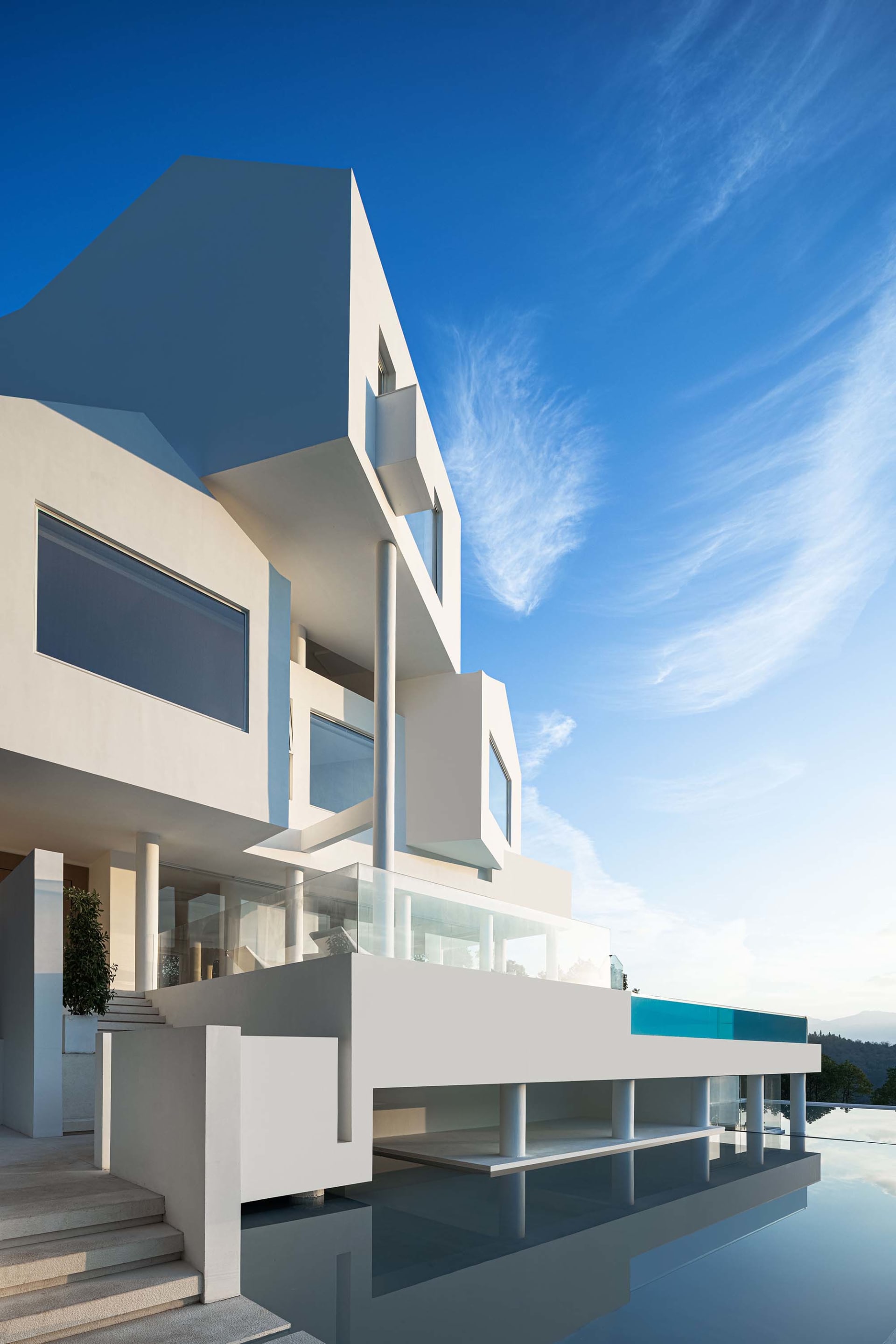 Modern residential building with large glass windows, concrete structure, and steel accents.