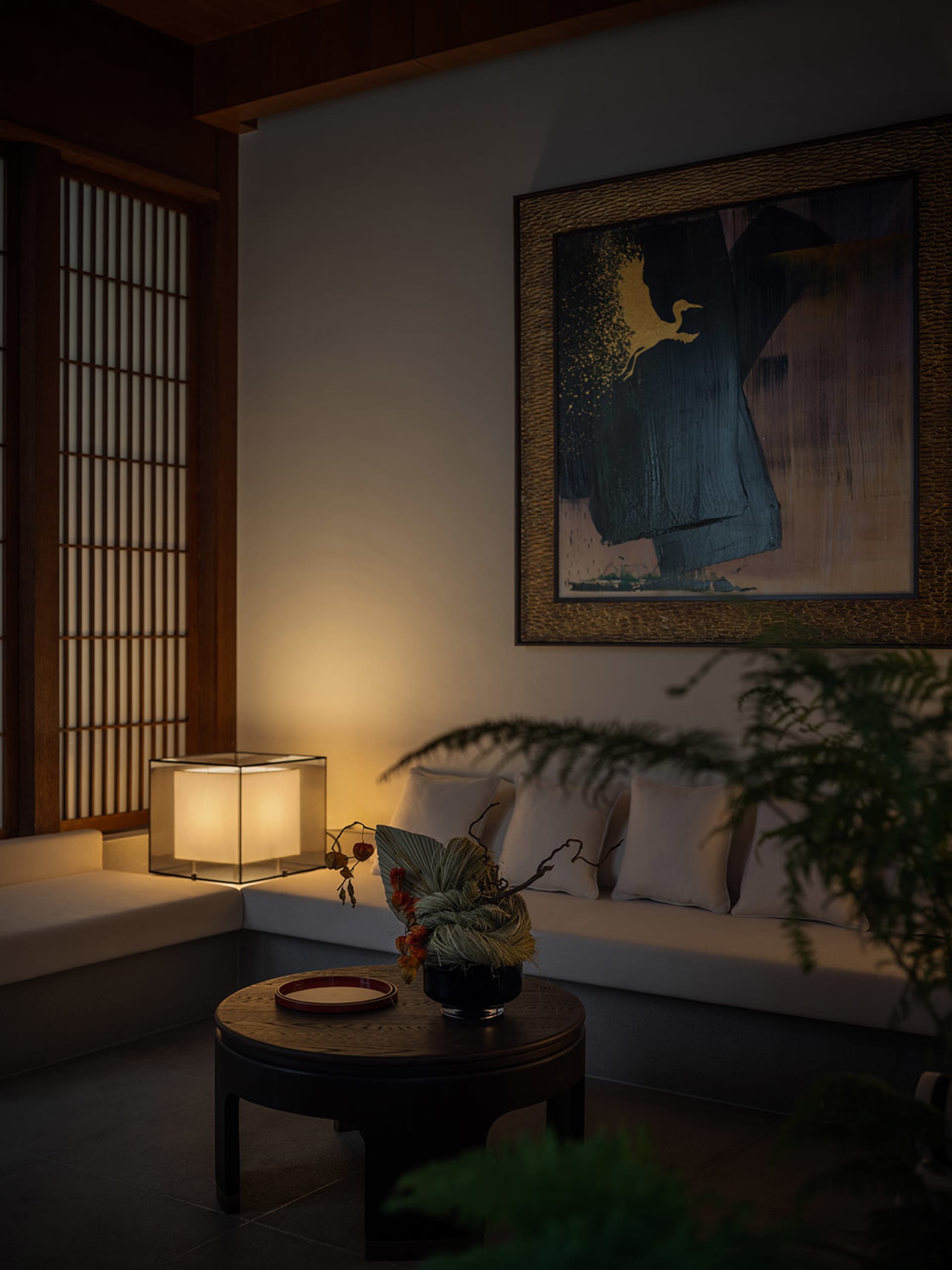 A cozy living room featuring neutral-tones furniture and a modern abstract painting.