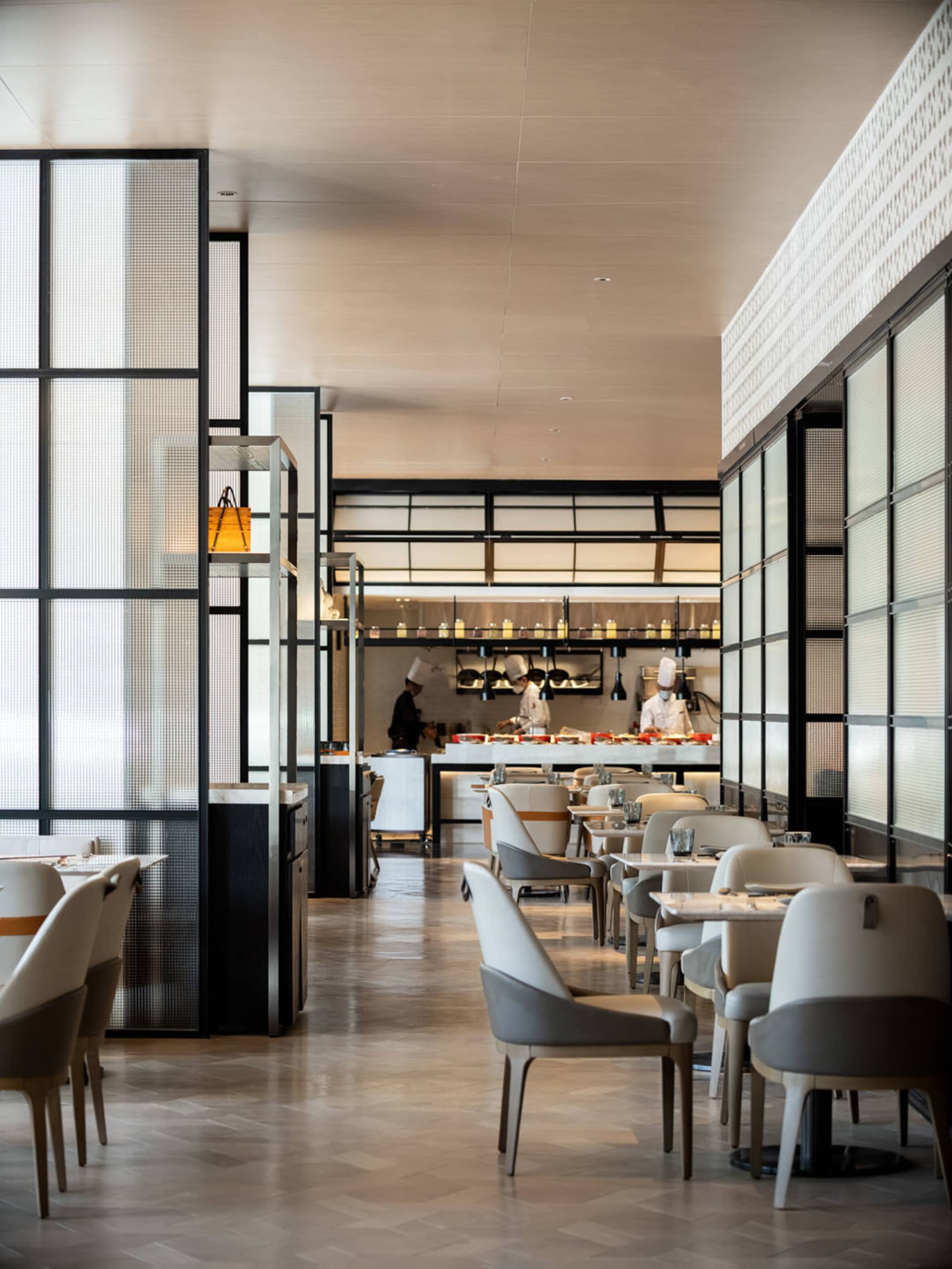 Modern restaurant interior with contemporary design featuring white chairs and tables.
