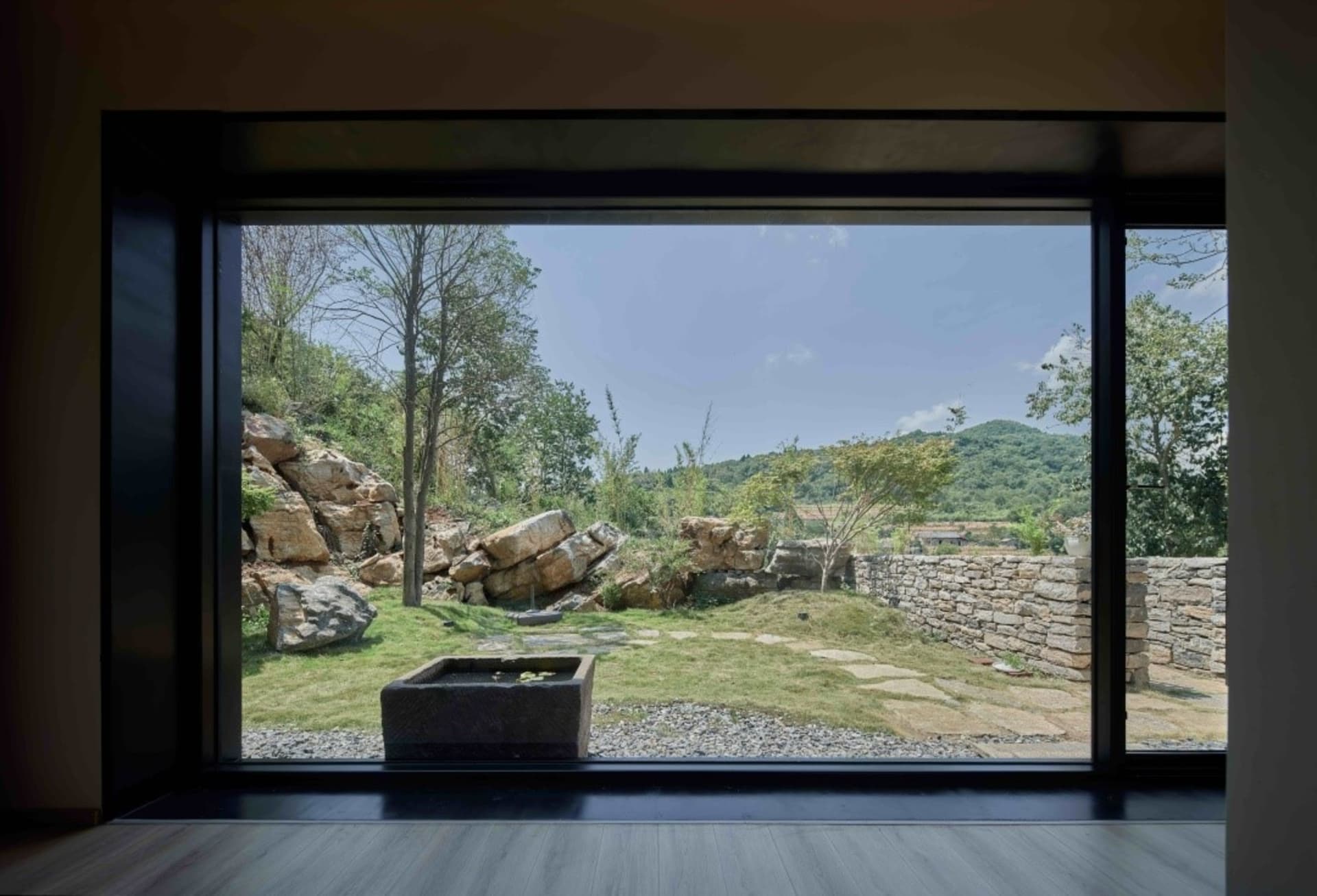 Outdoor space featuring natural stones and greenery within a landscape setting.
