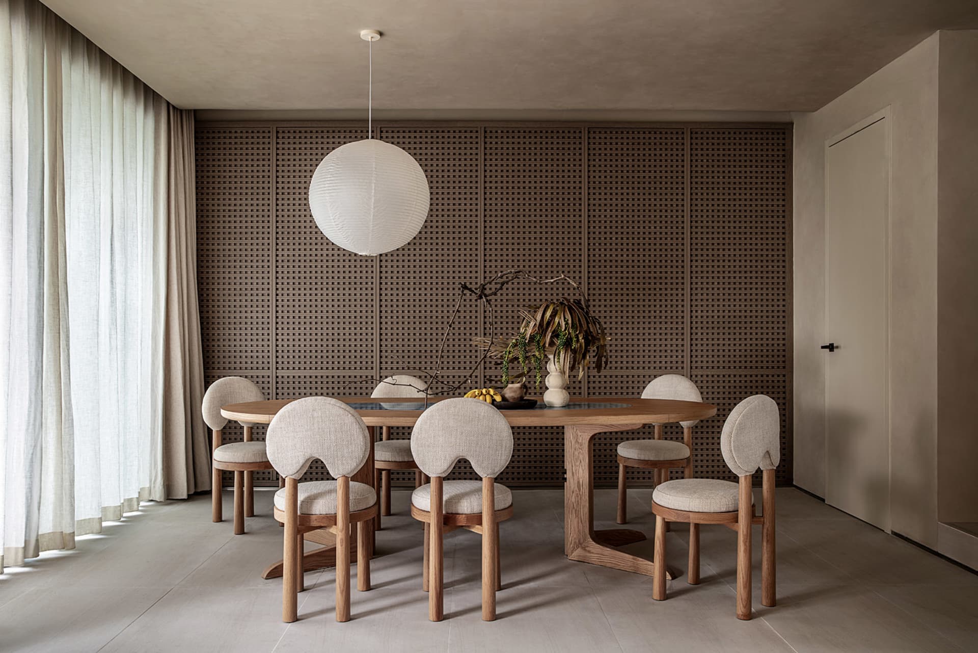 Modern dining room featuring a wooden table and chairs with linen upholstery.