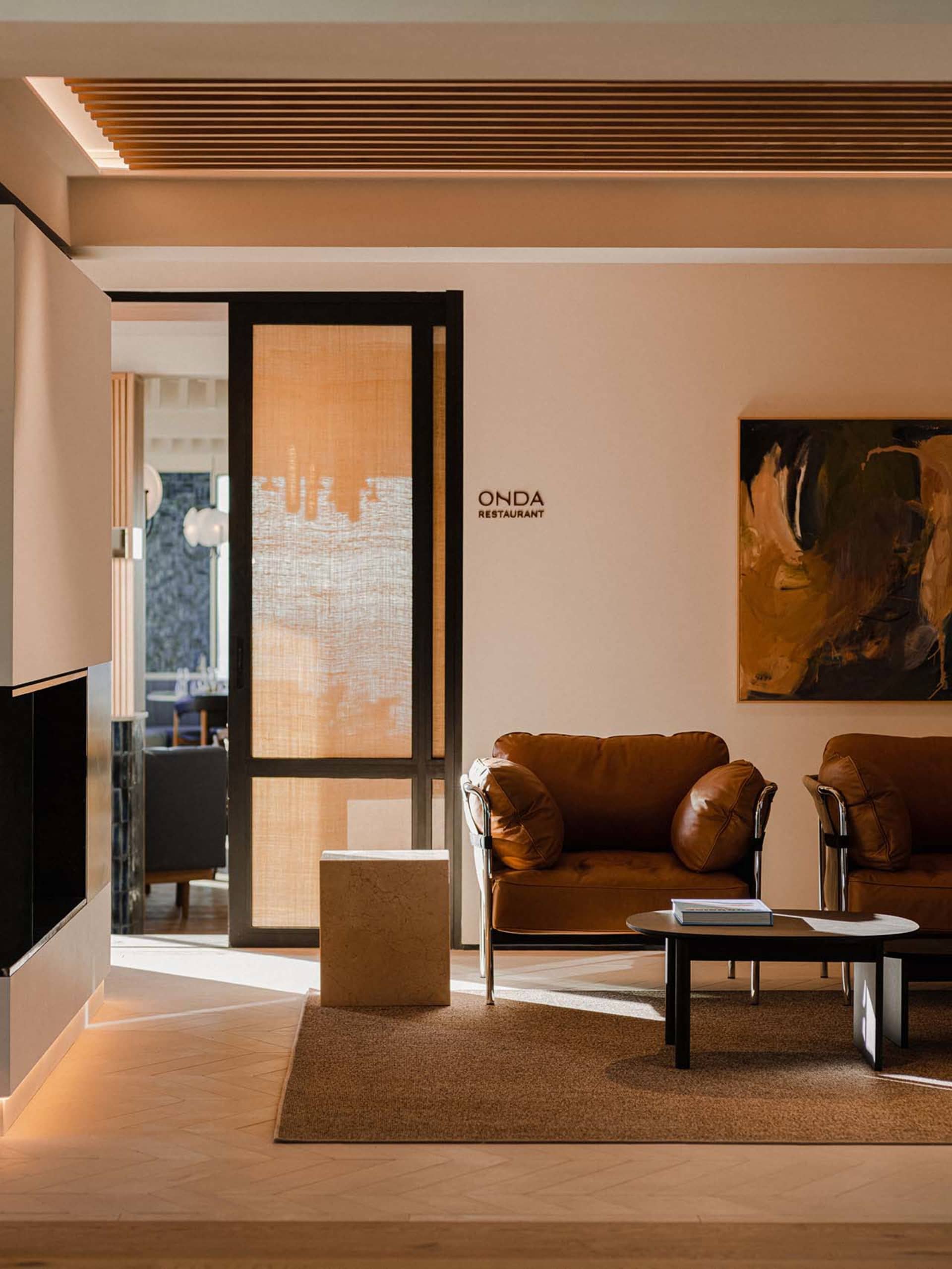 A modern restaurant with leather furniture and stone details.