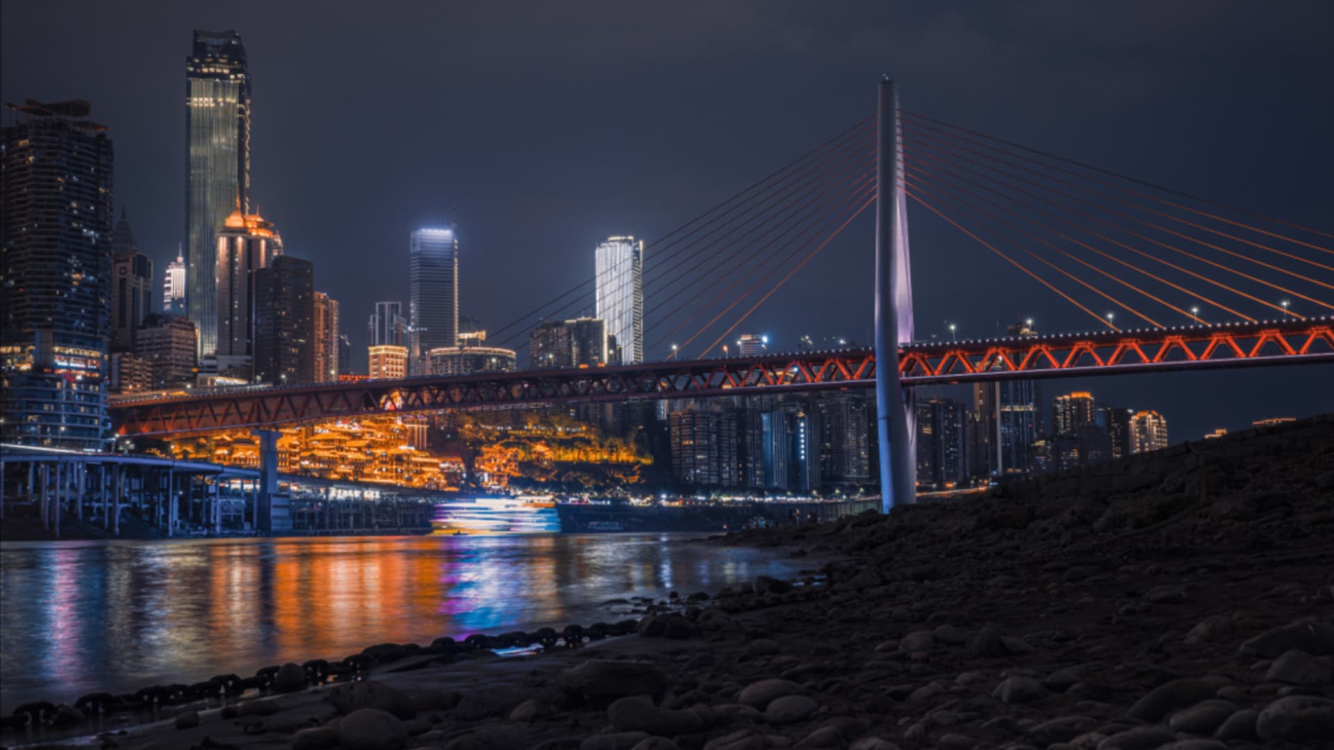 夜間城市景觀，呈現一座燈光照亮的橋樑及其在水面上的倒影。