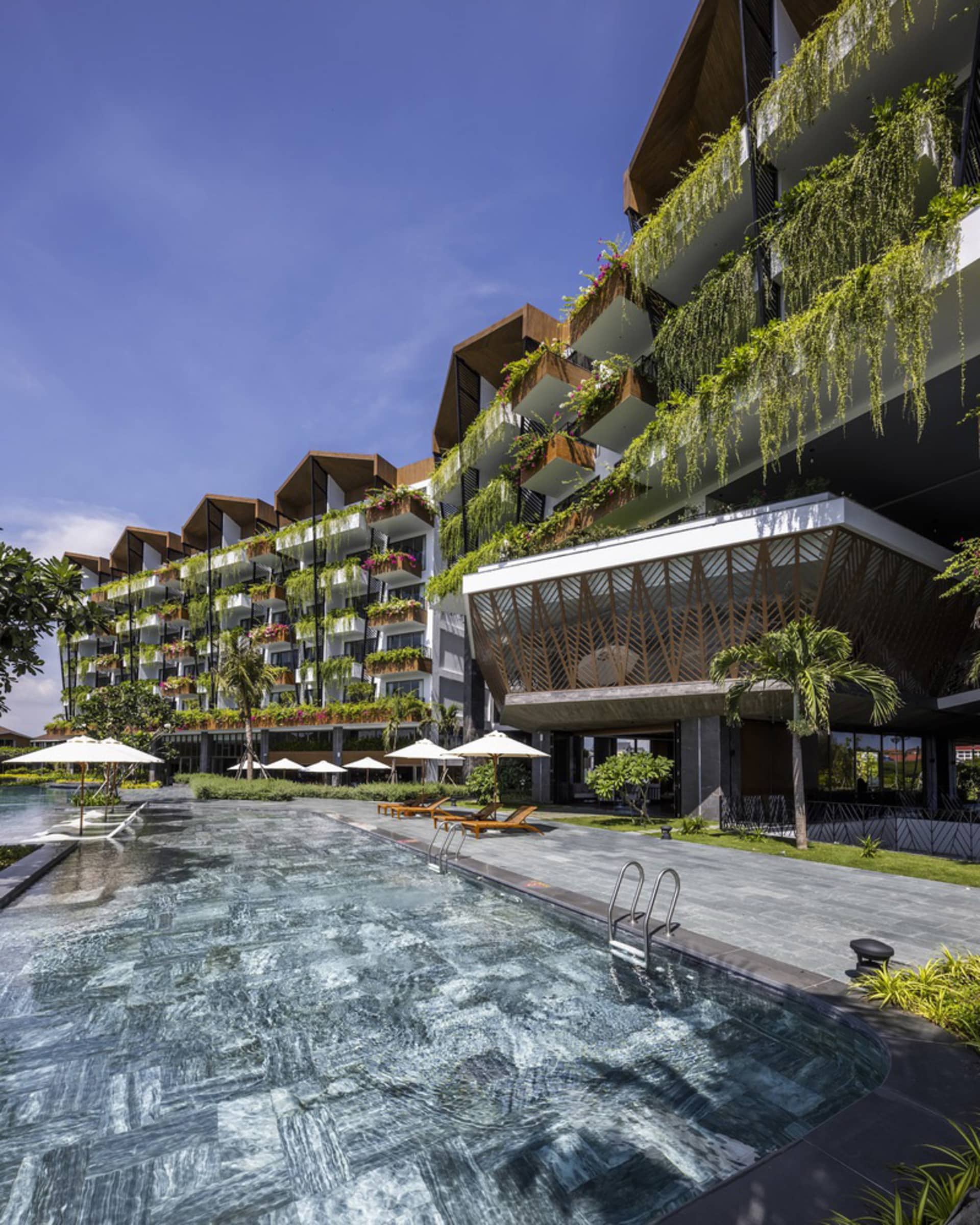 Modern residential poolside area featuring clay tiles and greenery.