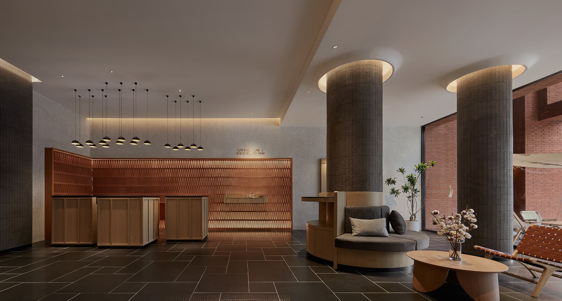 Modern hotel lobby with concrete pillars, walnut furniture, and hanging lights.