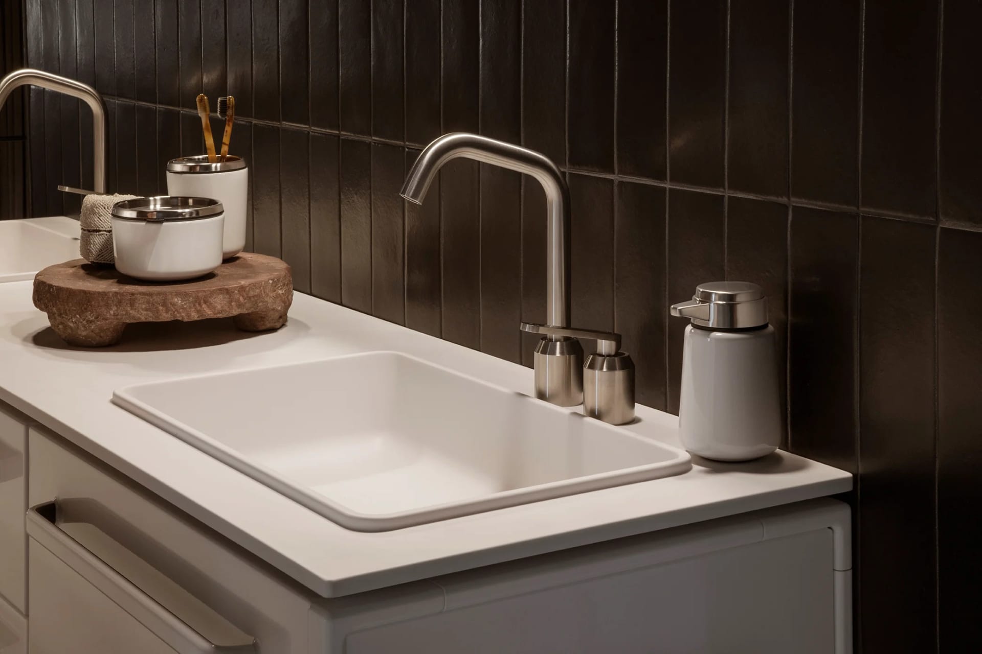 Modern bathroom with ceramic sink and metal faucet.