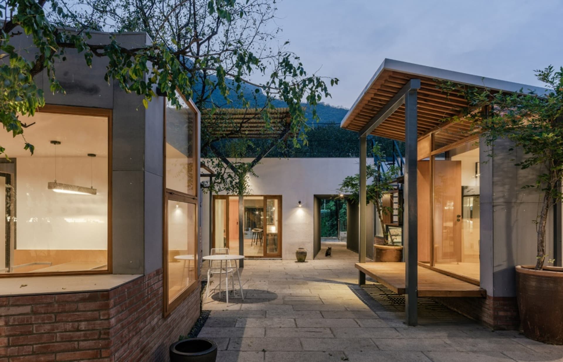 A modern residential exterior with brick walls, glass windows, and metal accents.