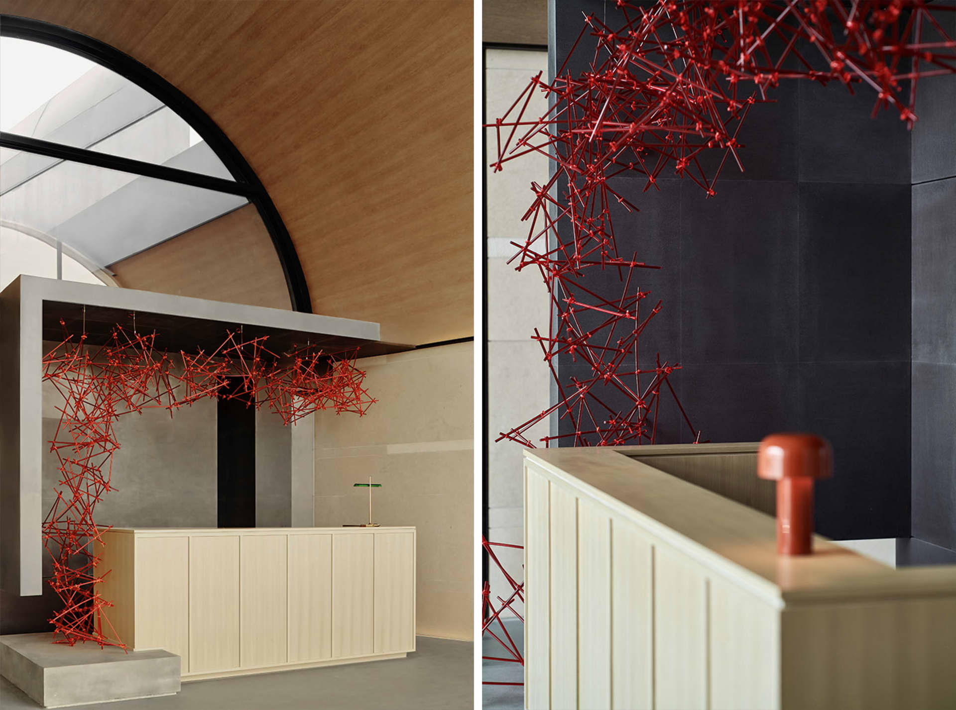A modern reception desk with a red metallic network design against a dark and white tiled background.
