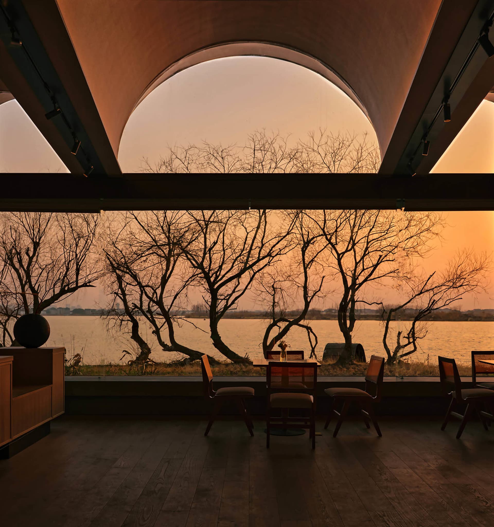 Interior view of a modern restaurant featuring wood architecture and a scenic water view
