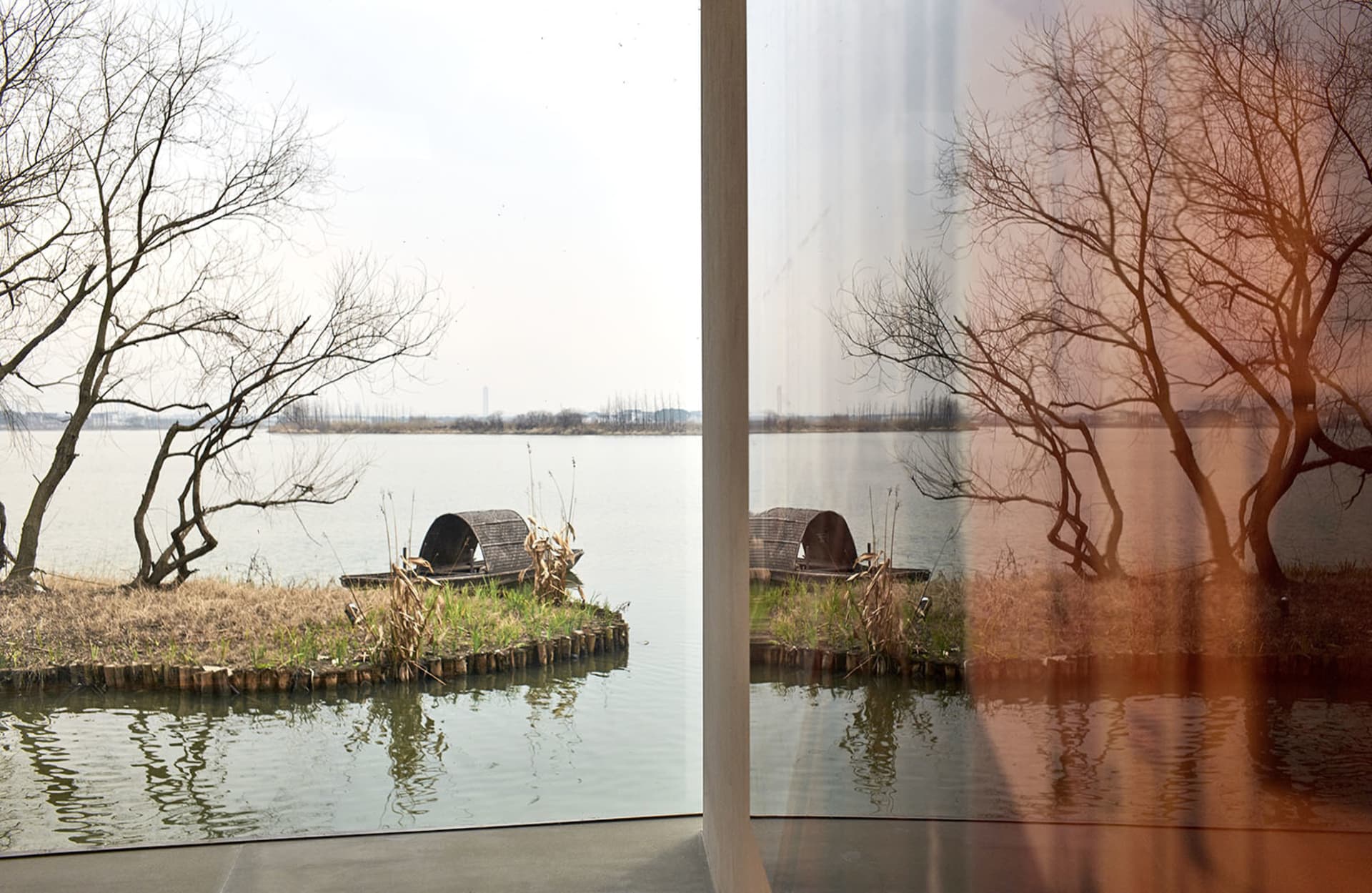 A serene waterfront scene reflected in a calm lake.