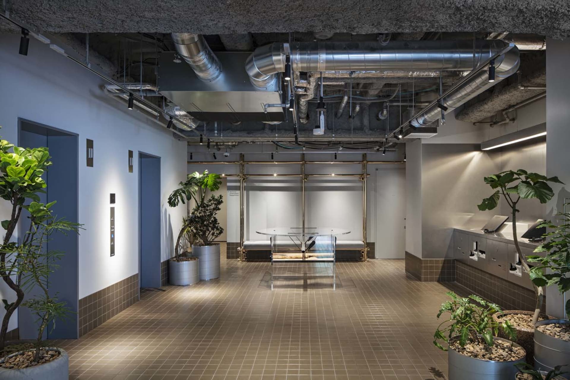 工業風辦公大廳採用混凝土與鋼材,展現現代設計,露出天花板管線與平台