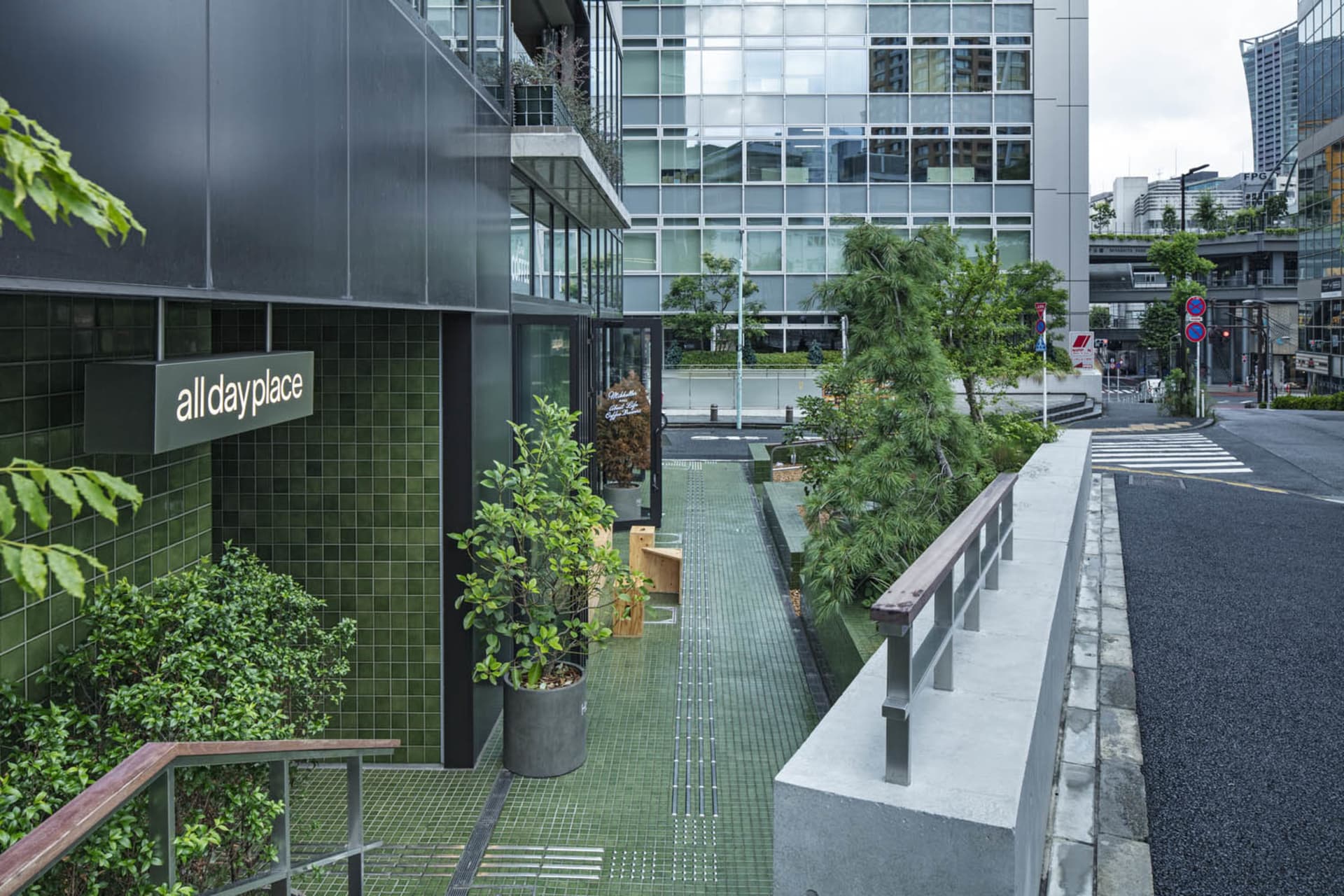 Modern office space interior with glass windows and greenery.