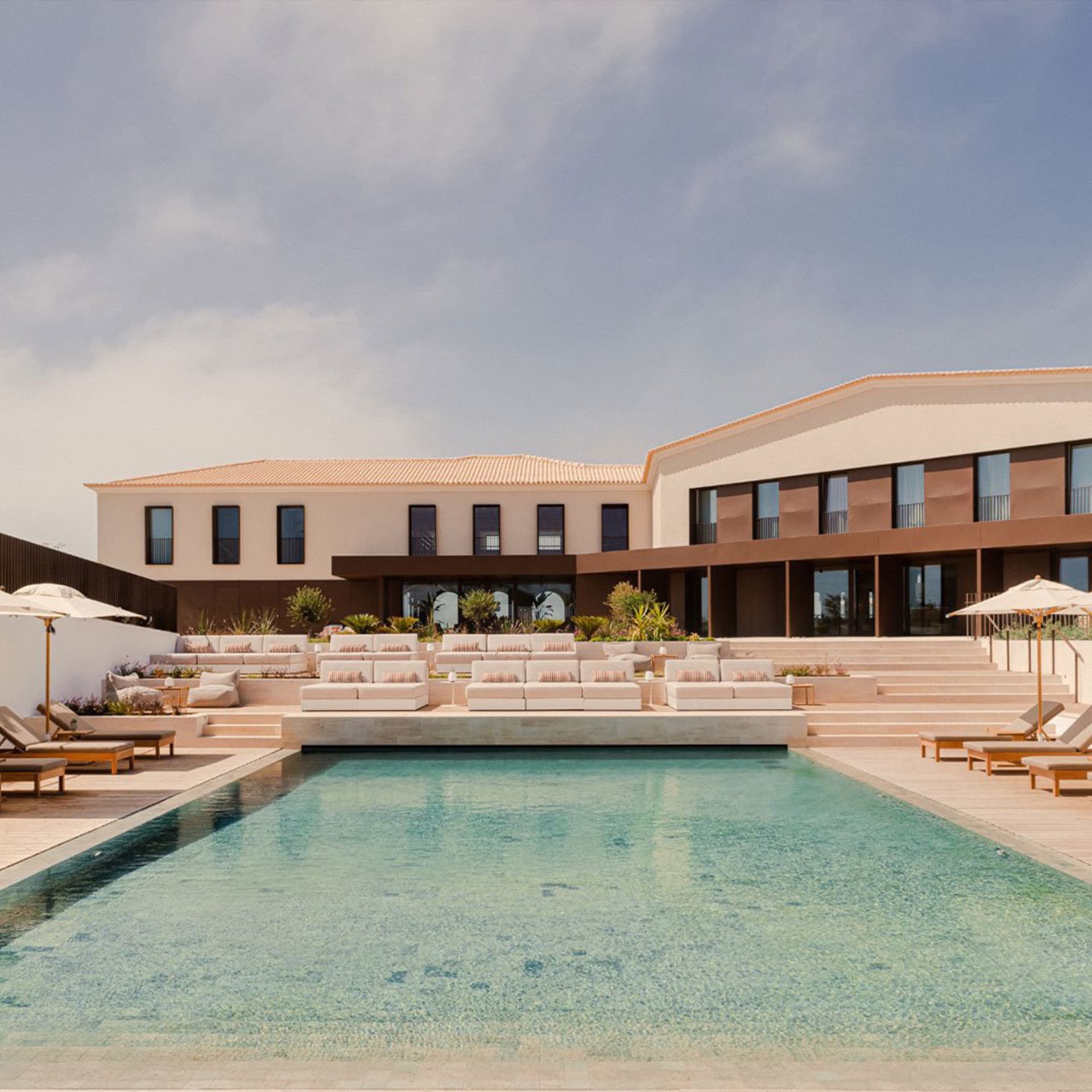 A modern residential space featuring a poolside lounge area with concrete and wooden elements.