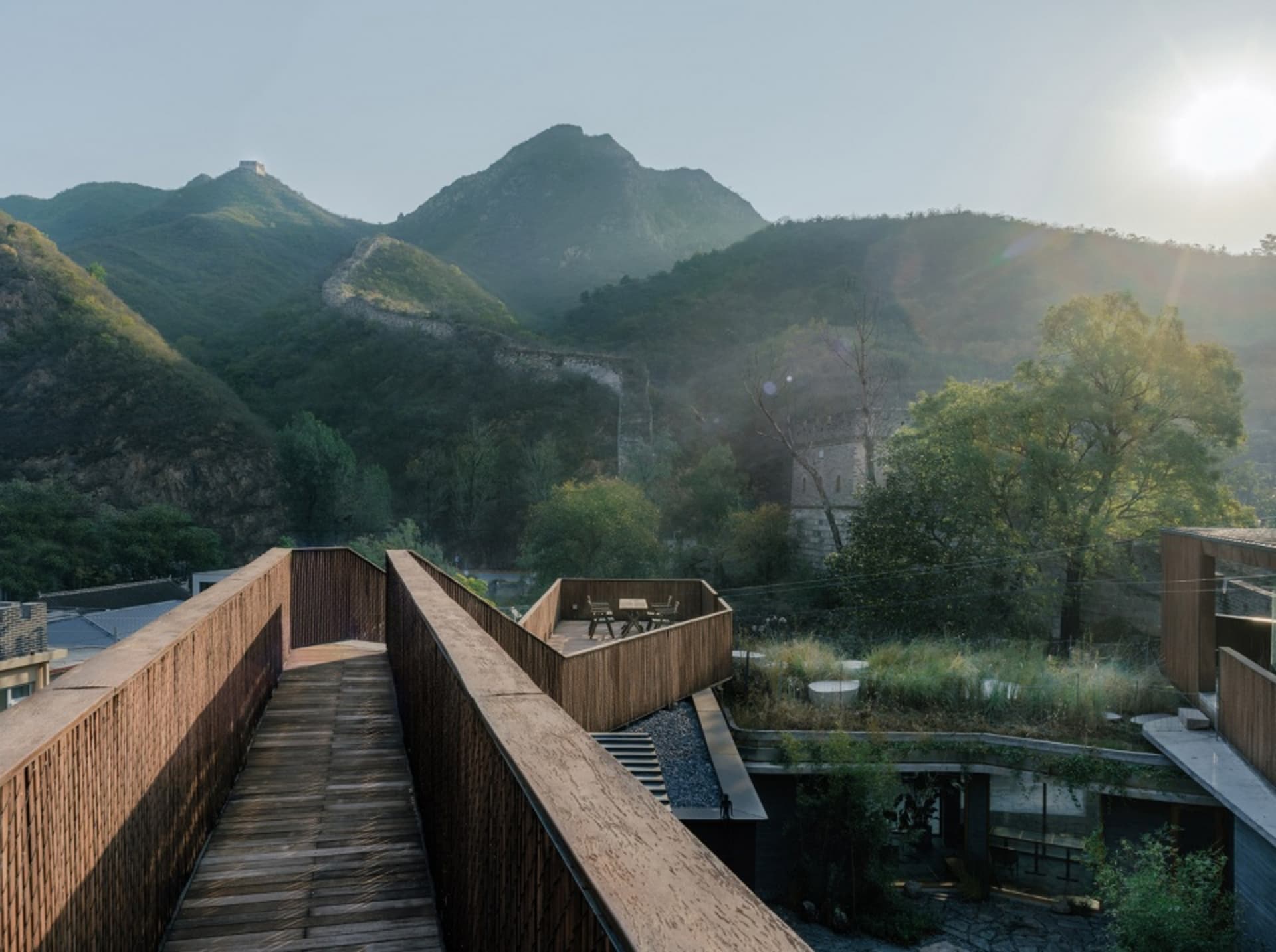 Modern wooden bridge over mountain with stone walls and metal railings