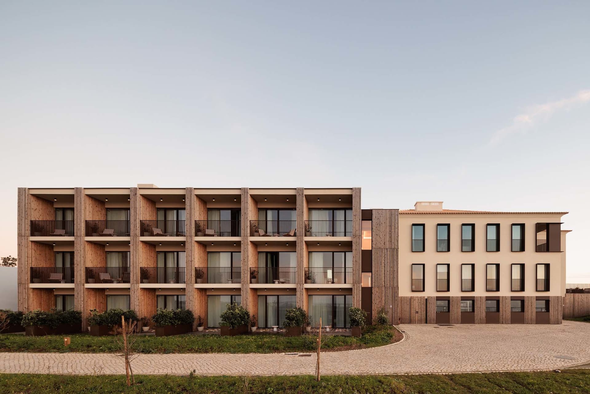 Modern residential building with wooden panels, concrete accents, and glass balconies.