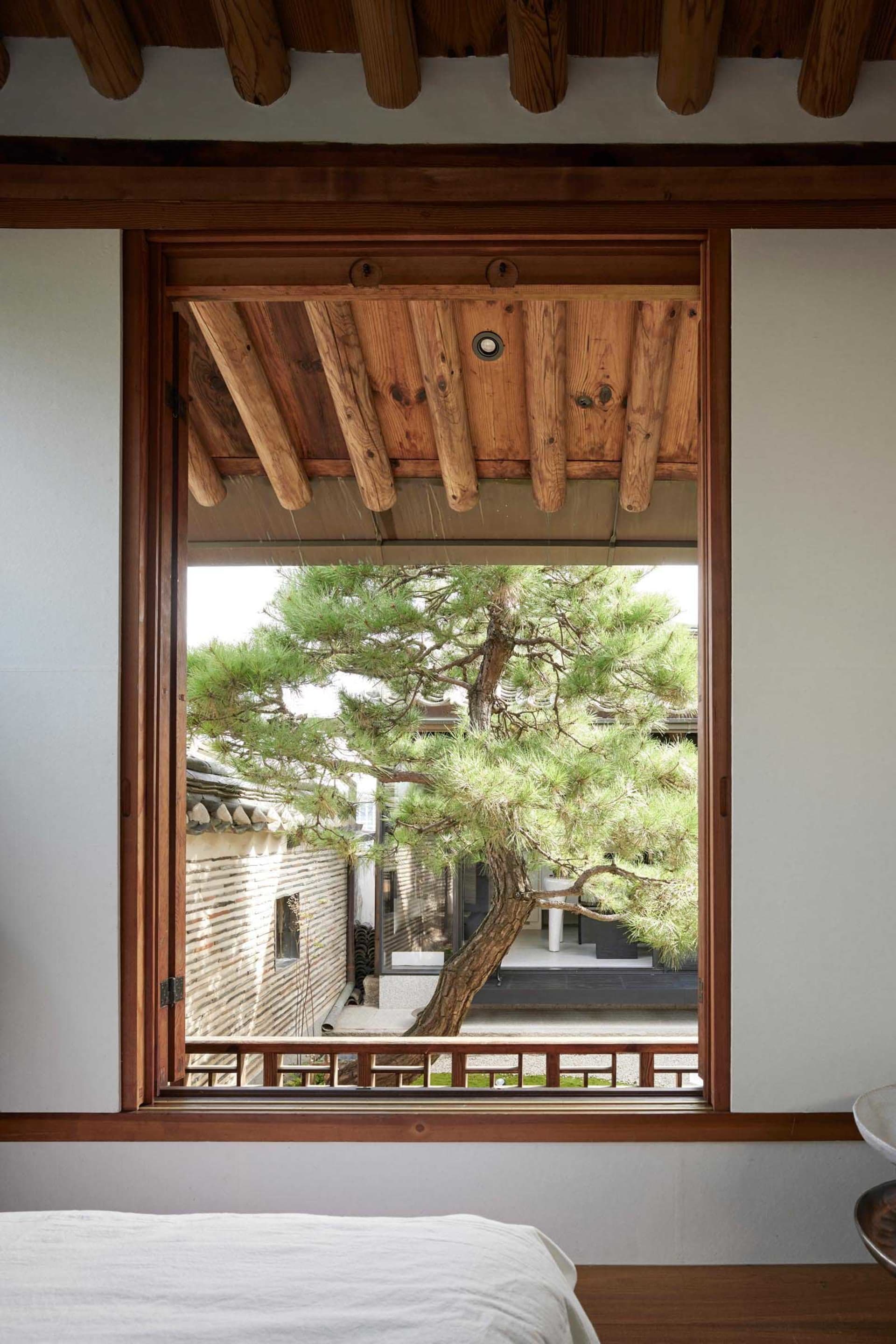 Traditional minimalist interior featuring wooden sliding doors with a view of the garden.