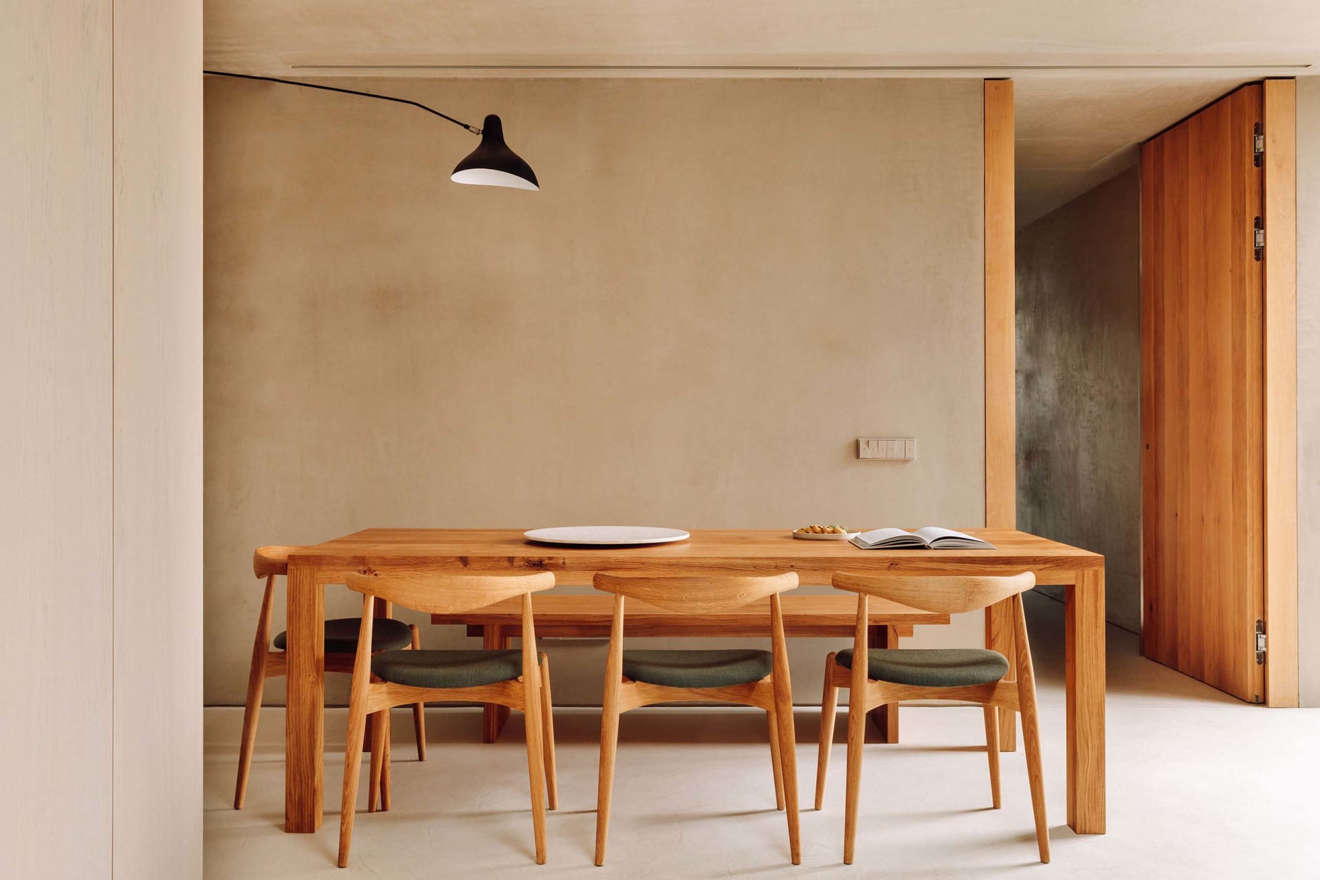 Modern dining room featuring minimalist furniture and wooden materials.