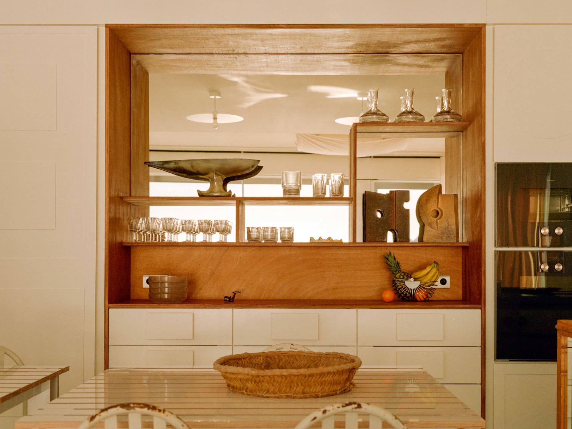 Modern kitchen featuring a wooden storage unit with glass shelves.