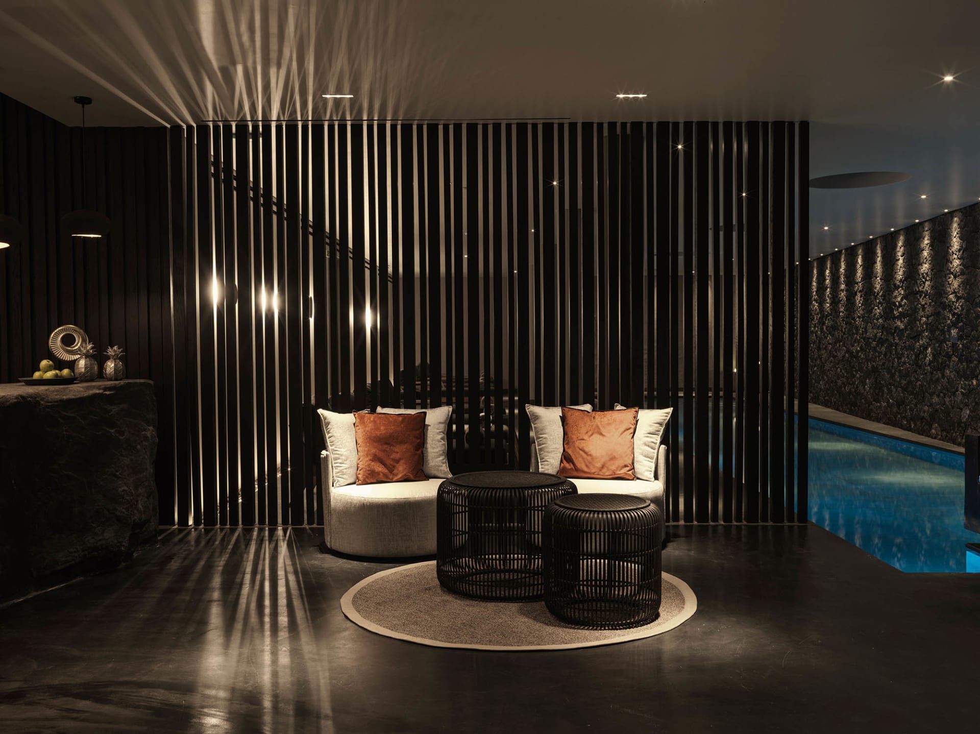 Modern living room with concrete furniture, round tables, and minimalist decor.