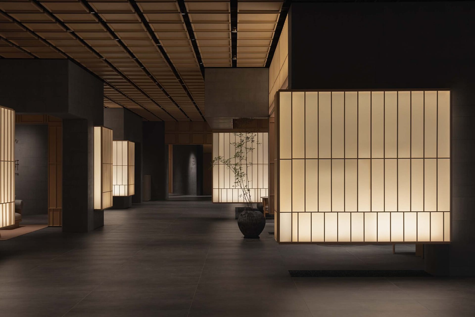 A modern and minimalist lobby featuring light wood materials and warm lighting.