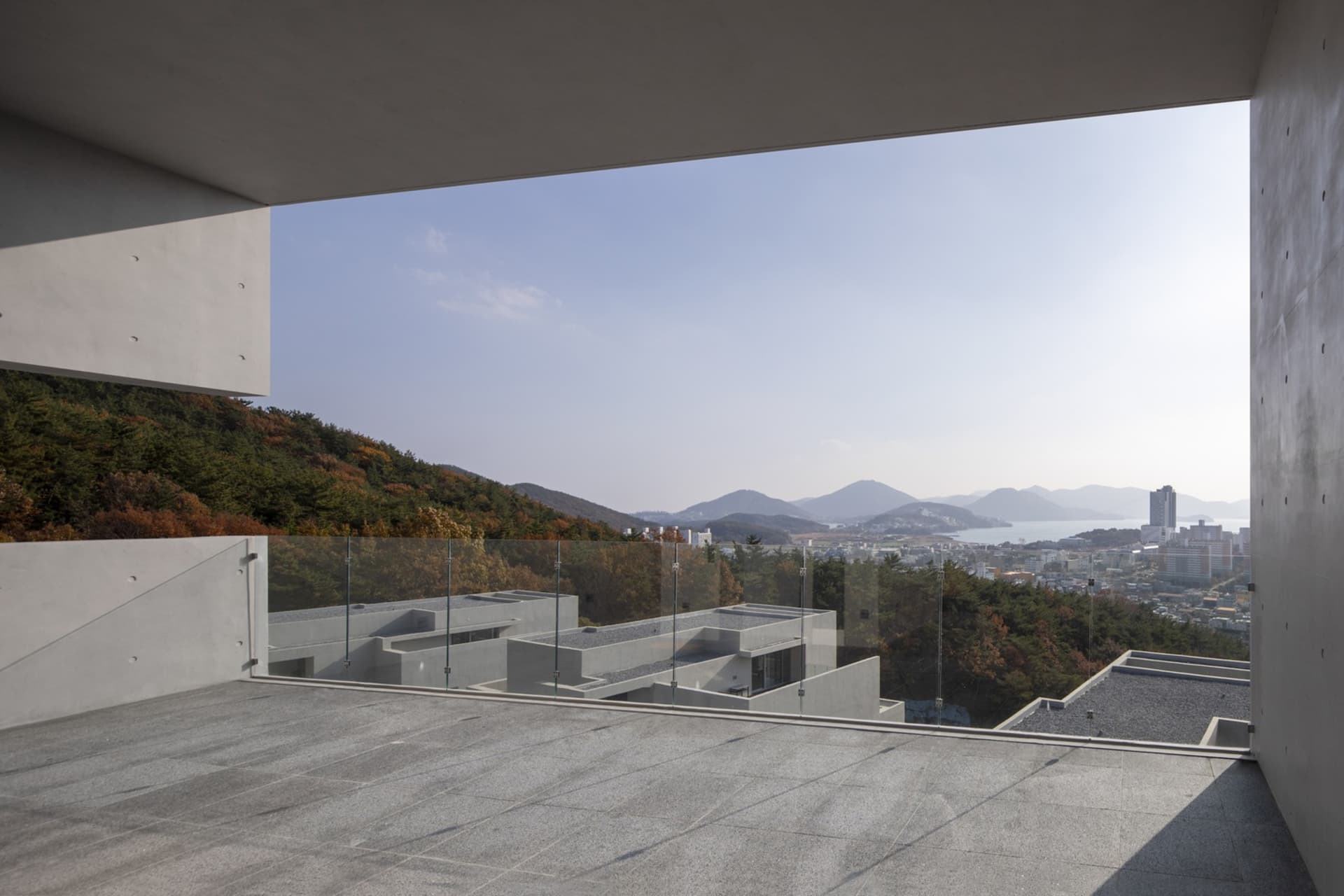 View from a modern building showcasing concrete materials and a scenic landscape.