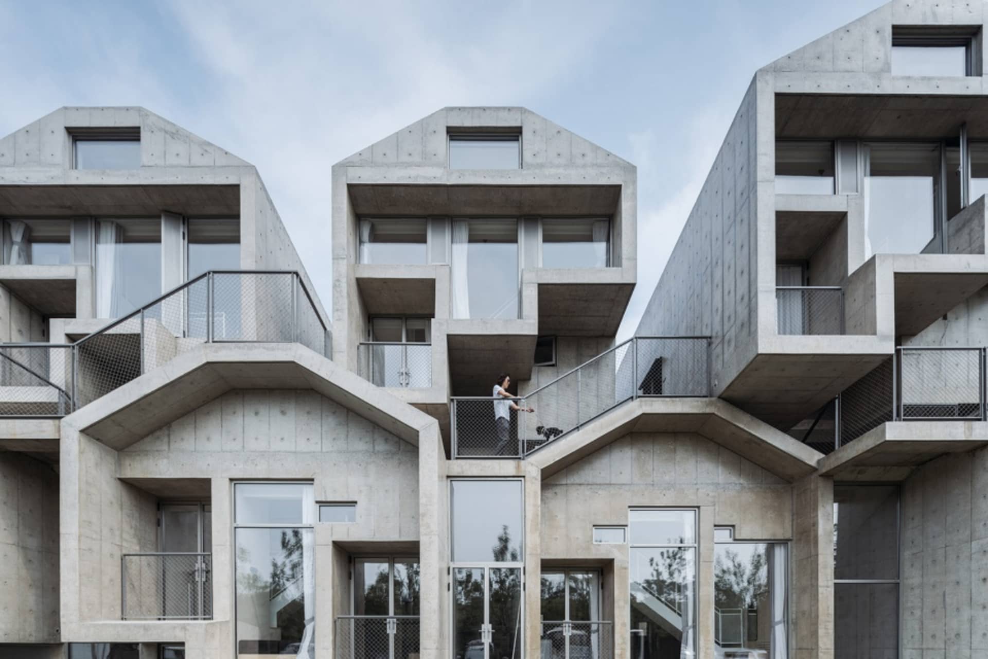 A modern, residential architectural design featuring stack houses constructed from concrete.