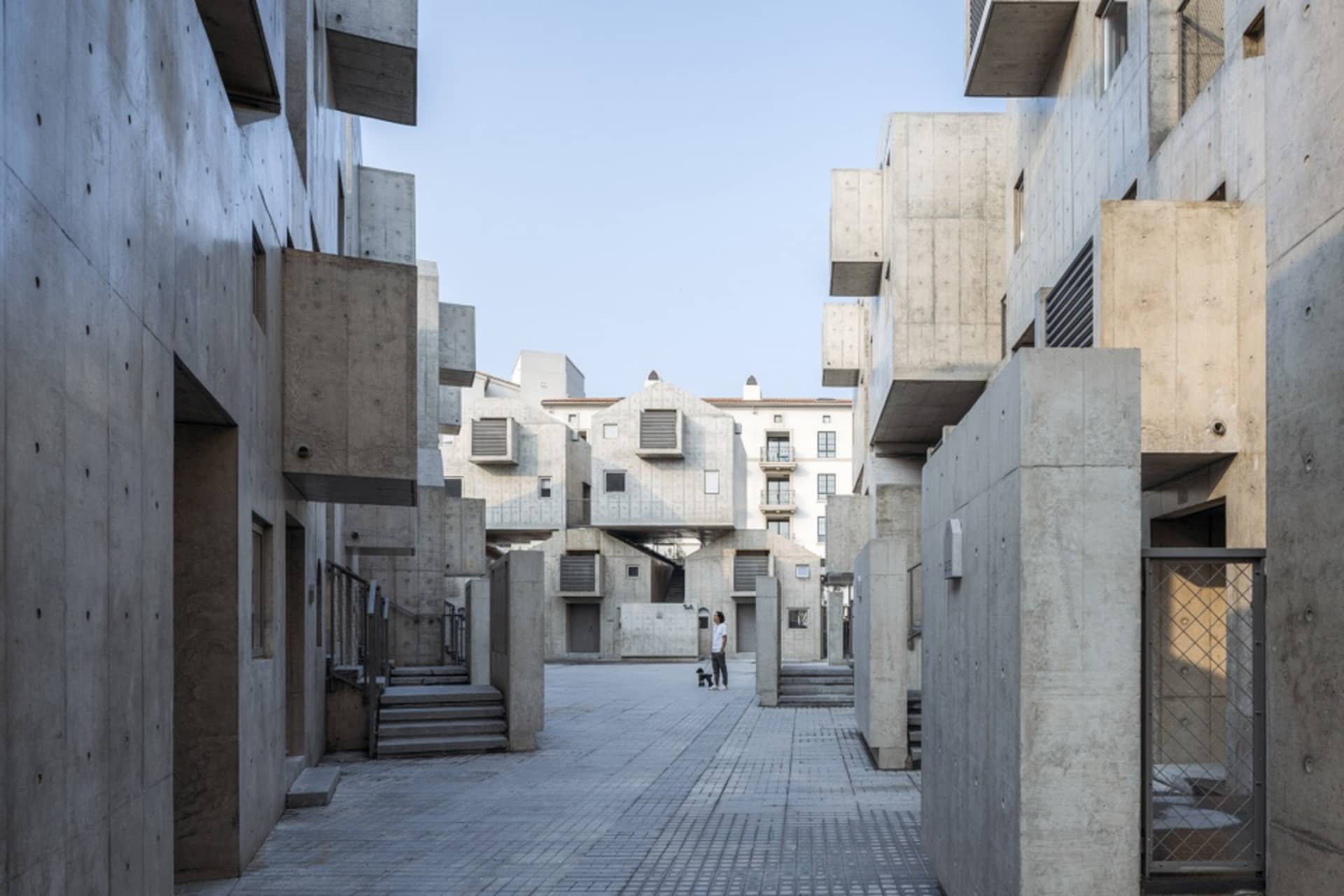 一座現代住宅大樓,擁有混凝土外牆與幾何建築元素。