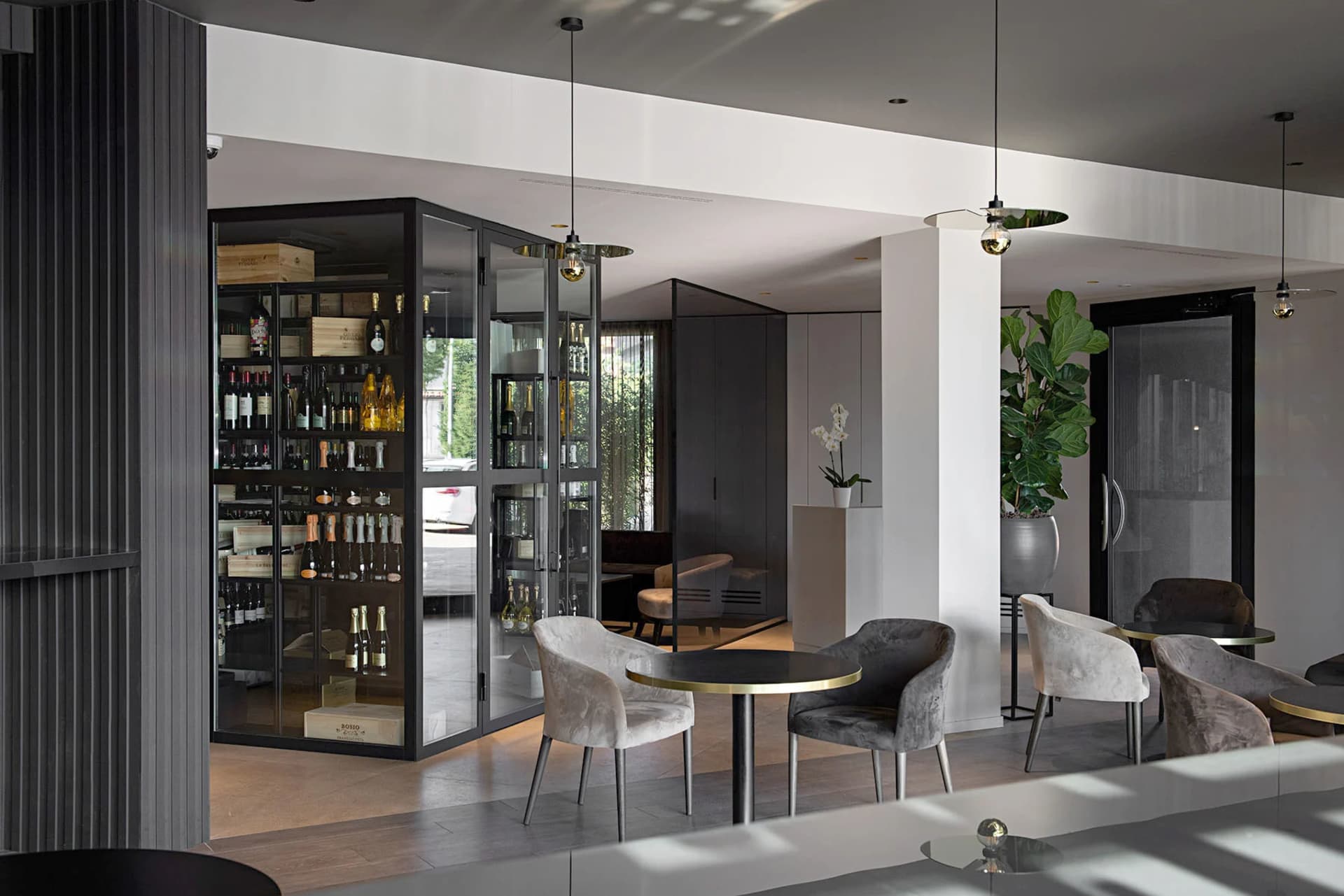 A minimalist restaurant lounge featuring glass, wood, and metal materials.