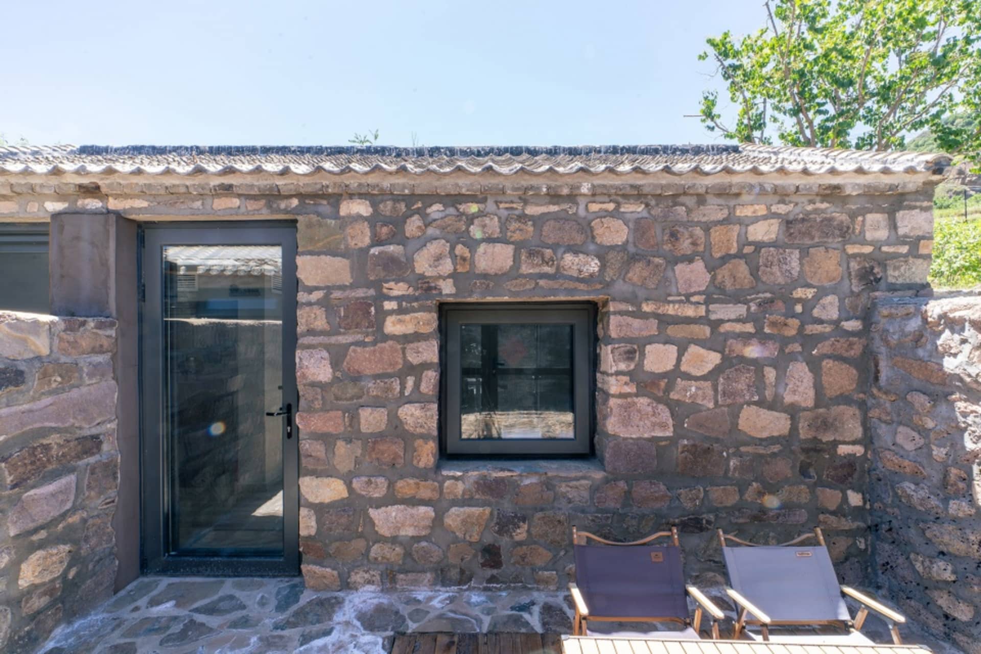 A minimalist stone exterior with a door and window.